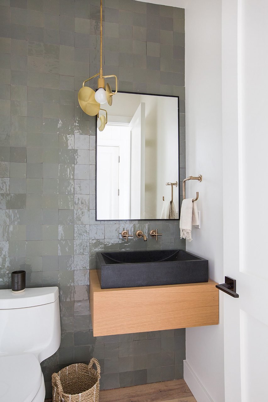 FLOOR-TO CEILING GLASS TILES AND A FLOATING SINK IN ONE OF THE BATHROOMS MARRY WITH BOHEMIAN FIXTURES.