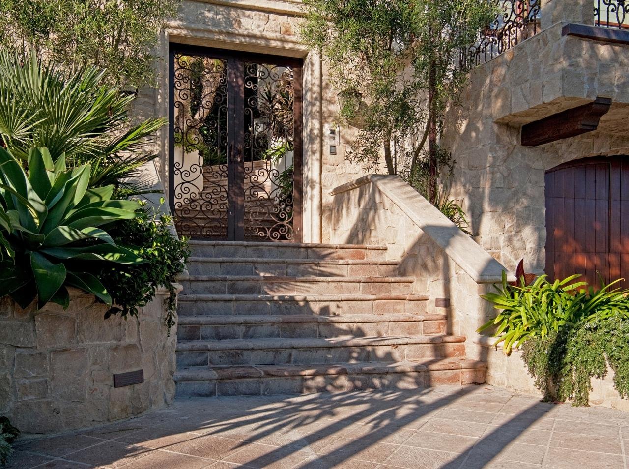 CUSTOM-MADE WROUGHT-IRON GATES COMPLEMENT THE MEDITERRANEAN THEME.