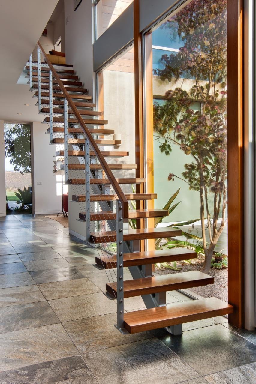 THE HOME FEATURES A “FLOATING” STAIRCASE WITH A CABLE RAIL SYSTEM AND WALNUT STAIR TREADS.