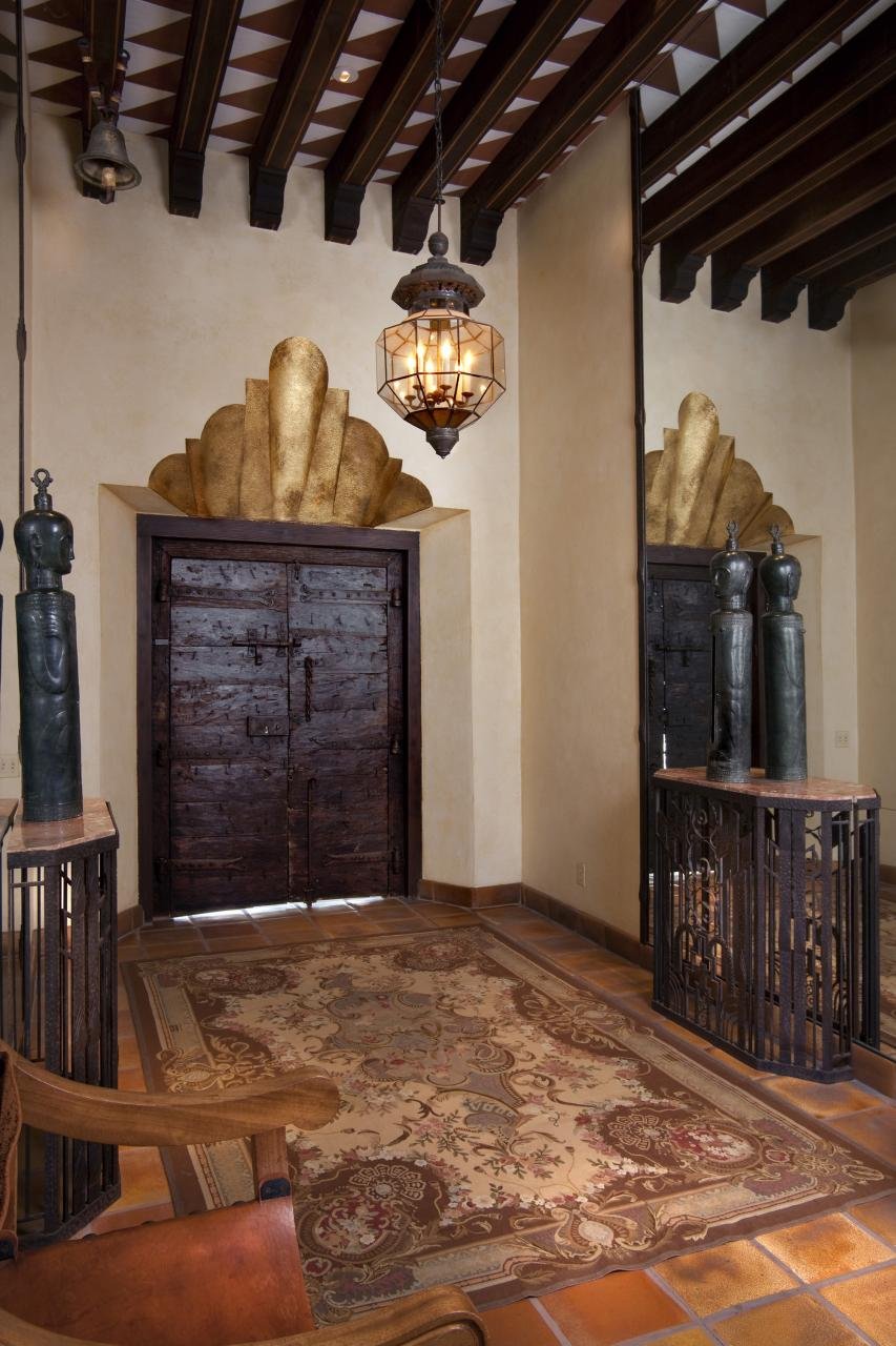 THE HOME’S MAIN ENTRANCE HAS A GOLD-LEAF RELIEF AND CUSTOM SPANISH-TILE ROOF.