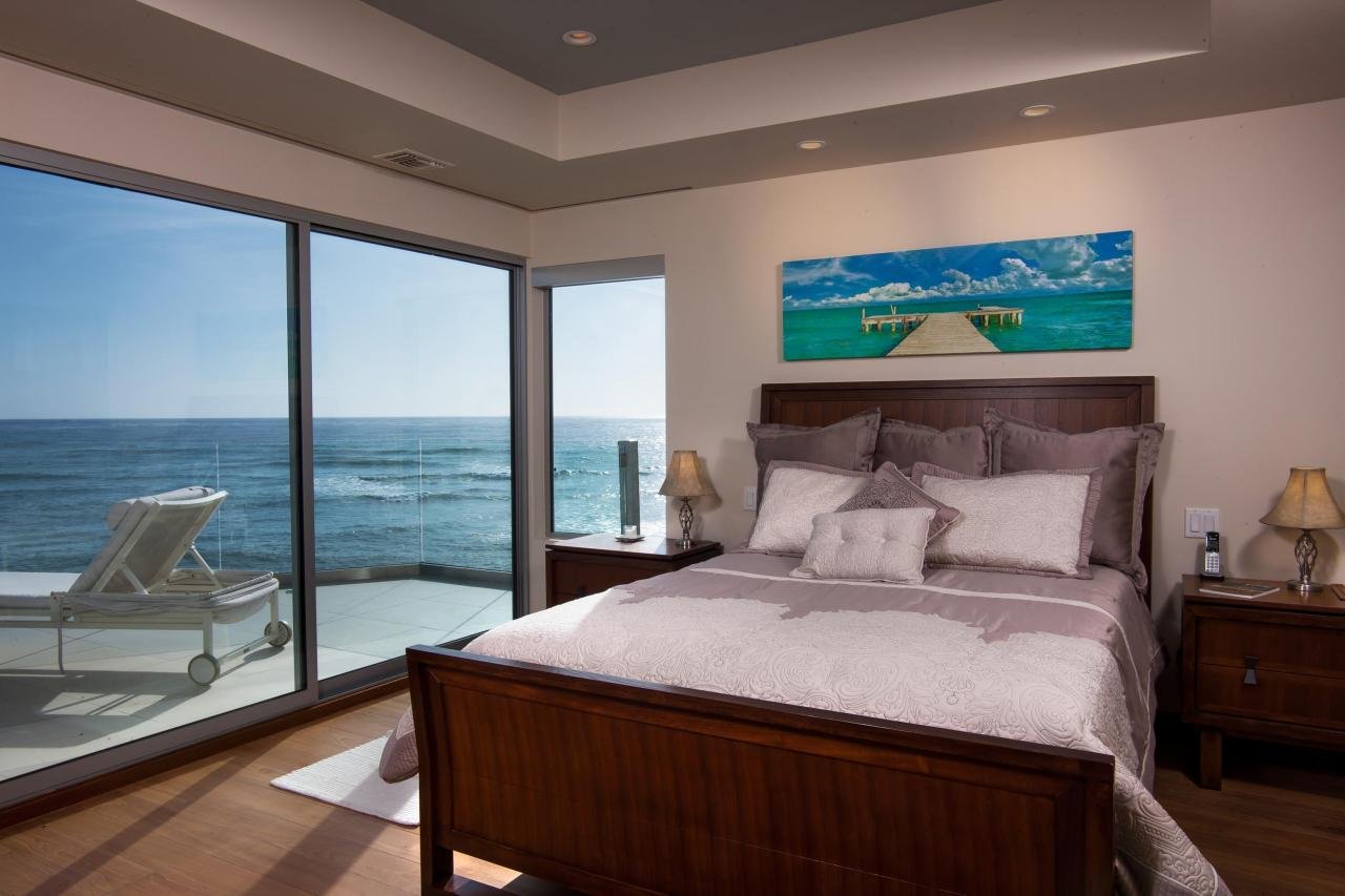 THE GUEST BEDROOM HAS FLEETWOOD SLIDING DOORS THAT LEAD OUT ONTO AN OCEANFRONT PATIO. THE DOORS ALSO HAVE HIDDEN, RECESSED BLACKOUT SHADES FOR PRIVACY.