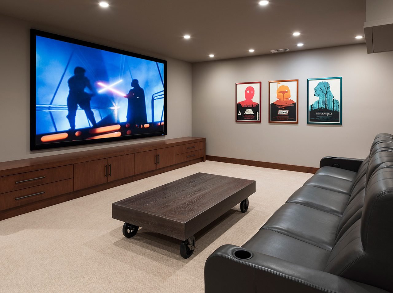 AN OVERSIZED PROJECTION SCREEN HIDES A CUSTOMIZED SPEAKER SYSTEM IN THE ENTERTAINMENT CENTER.