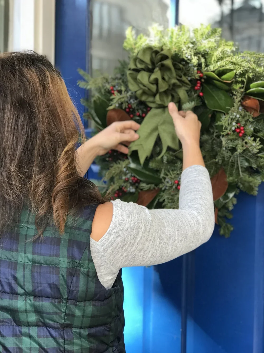 Jersey City florist hanging a holiday wreath