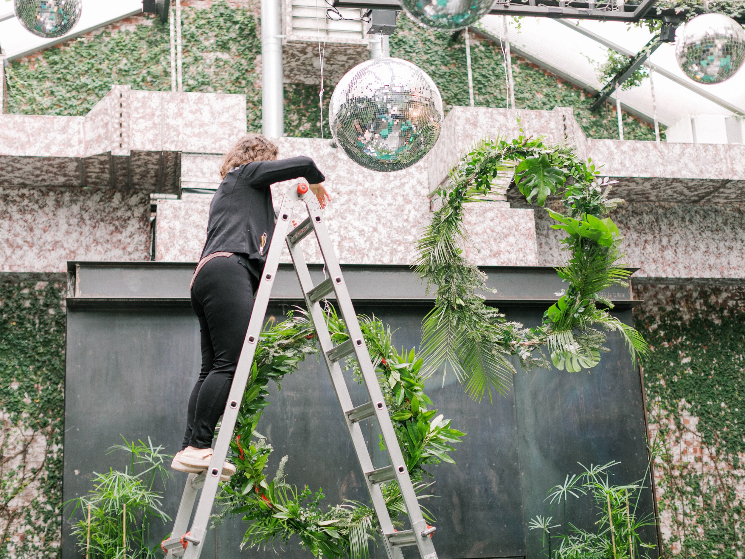 NYC floral designer setting up a greenery installation