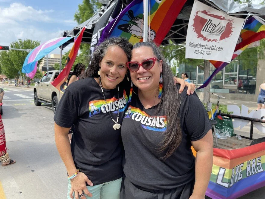 Image of Co-Founders of Cousins, Kendra Wilson-Clements and Sarah Adams, wearing Cousins T-Shirts at their float for the pride parade.