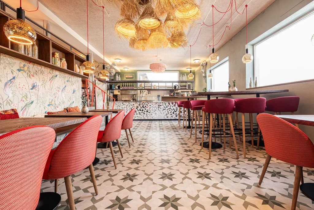 Boho-inspiriertes Restaurantinterieur in der sit hütte Arosa mit Holz, Spiegelmosaik und alpinem Charme.