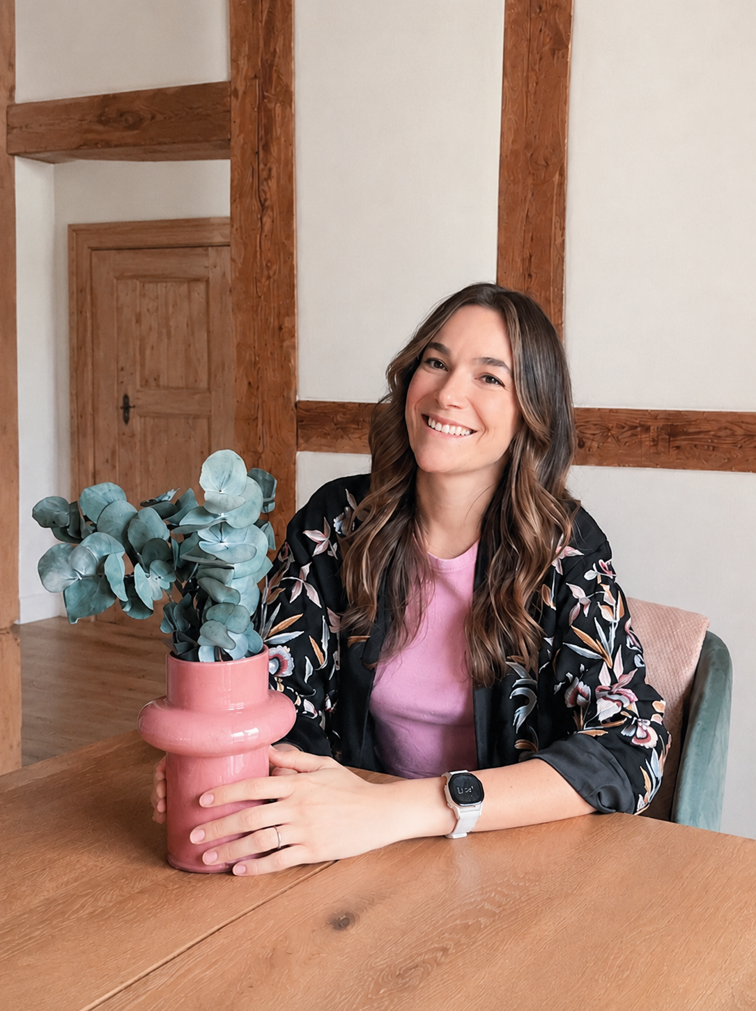 Interior Designerin Rebecca Morgenthaler an einem Holztisch in ihrem Chalet in Arosa – natürliche Materialien, kreative Raumgestaltung und zeitloses Design.