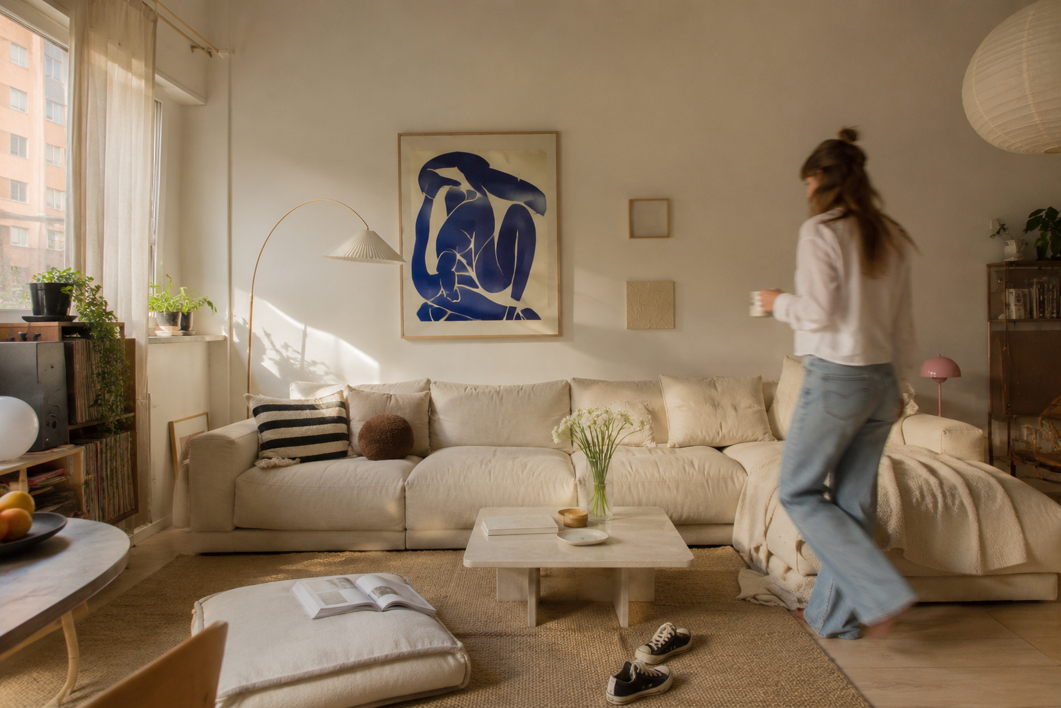 Helles, warmes Wohnzimmer in einer stilvollen Wohnung mit skandinavischem Flair, natürlichen Materialien, Pflanzen, Kunst und gemütlicher Sofa-Ecke.