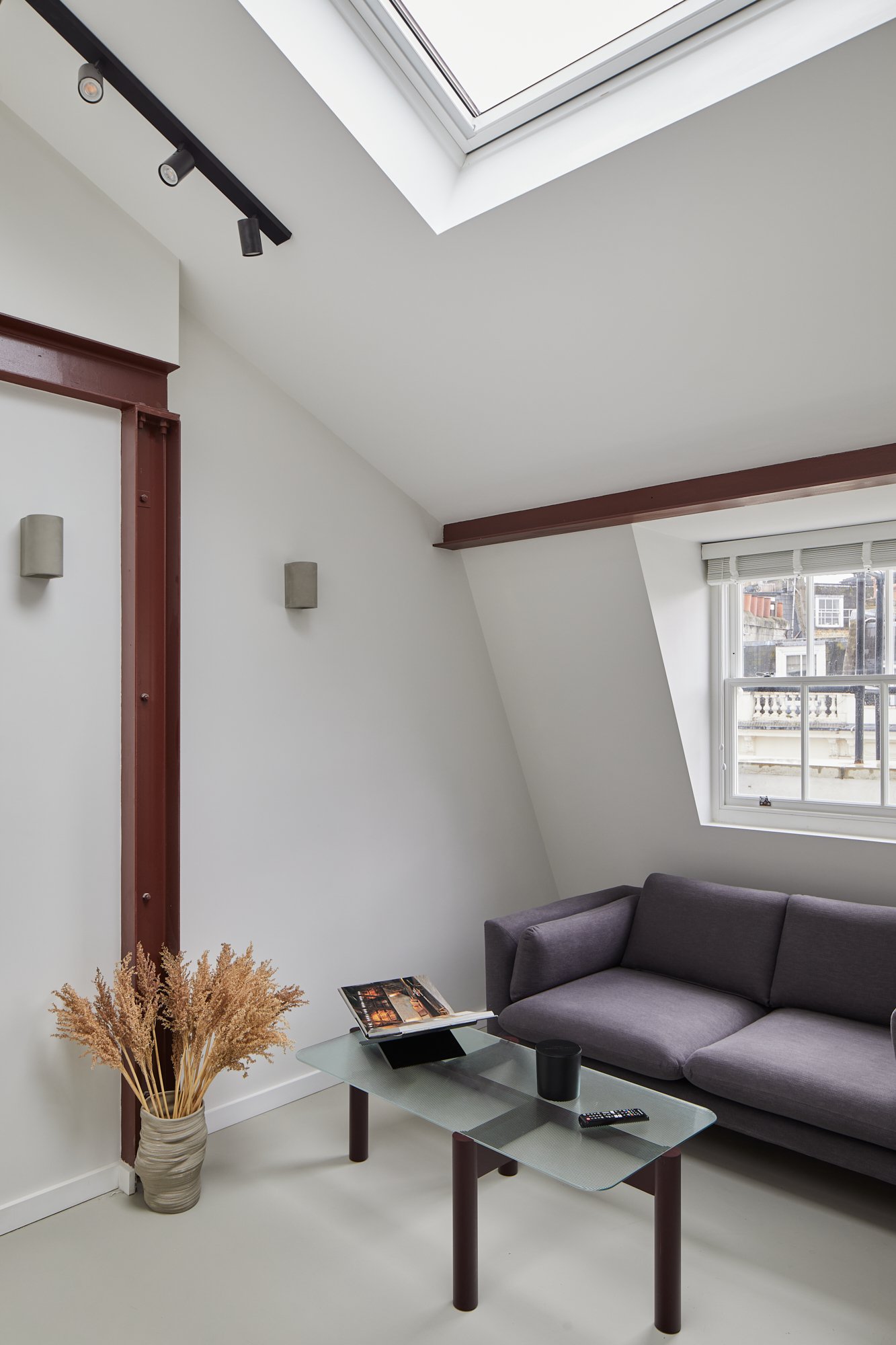 Skylights brighten up this open plan London SW1V apartment, red steel beams and track lighting give this an industrial feel to the space