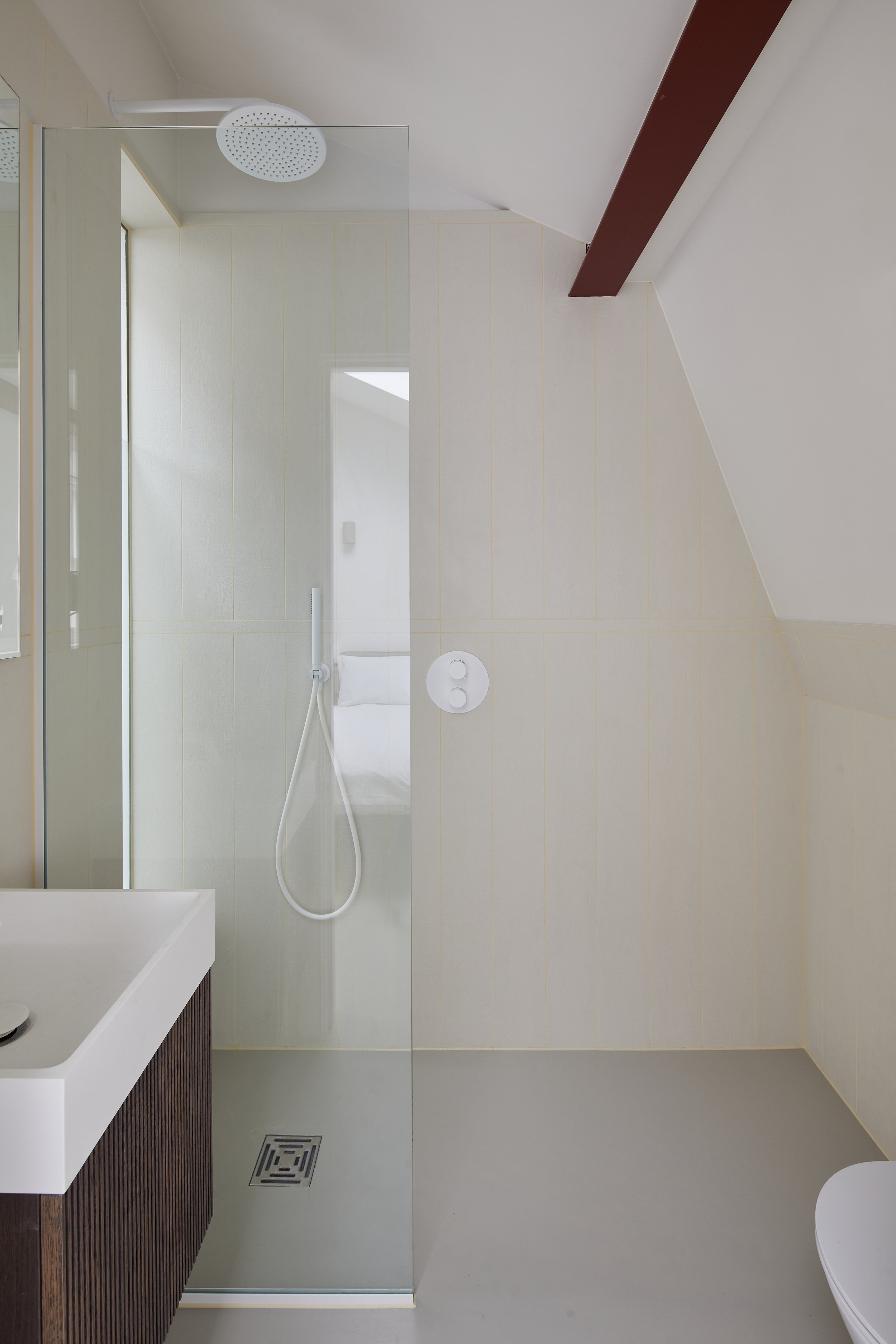 White bathroom with dark wood accents, grey flooring, white furnishings and an orange grout for a pop of colour London SW1V