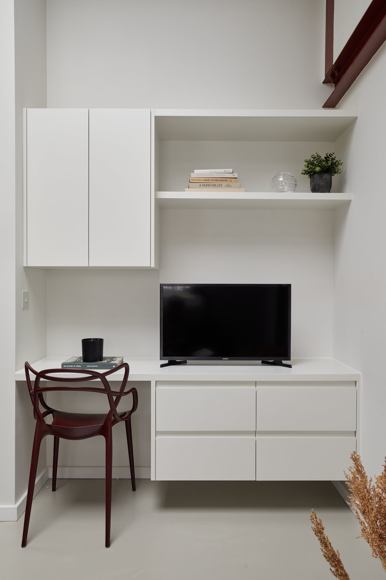 Custom cabinetry, a joint television stand and work desk make the best of the small amount of space. London SW1V