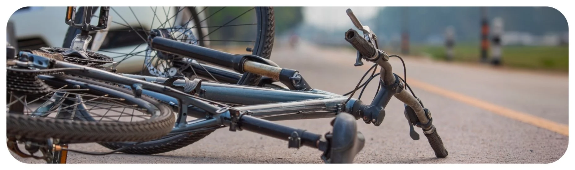 Damaged bicycle lying on the road after a crash, illustrating the impact of bicycle accidents in Iowa.