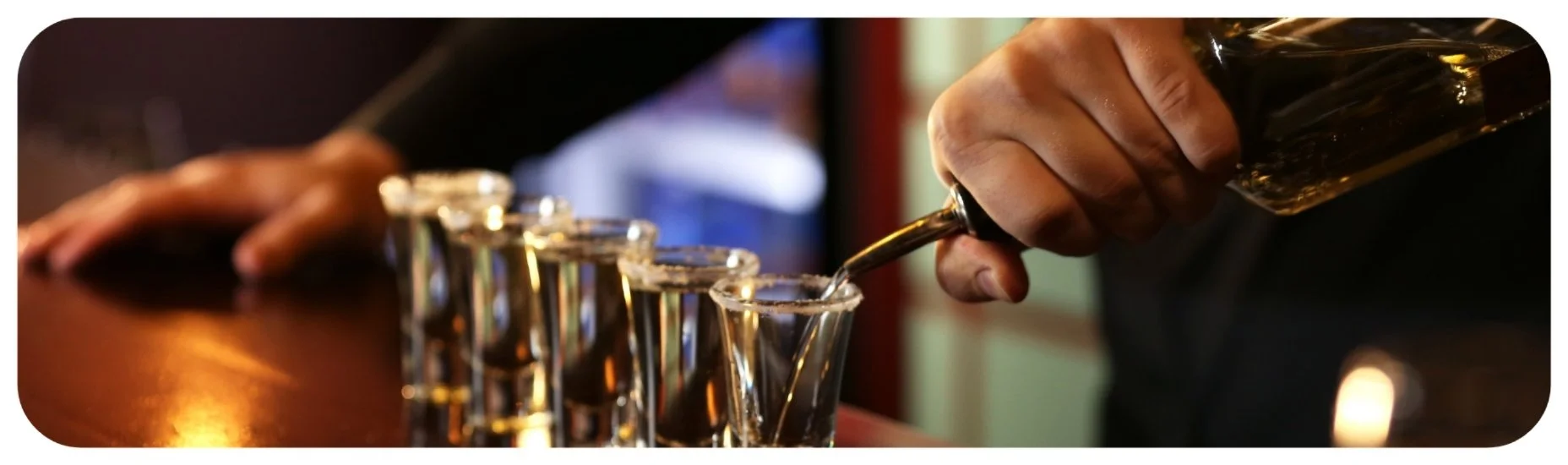 Multiple shots being poured at a bar, representing Iowa dram shop litigation involving rapid alcohol service and binge drinking by intoxicated patrons.