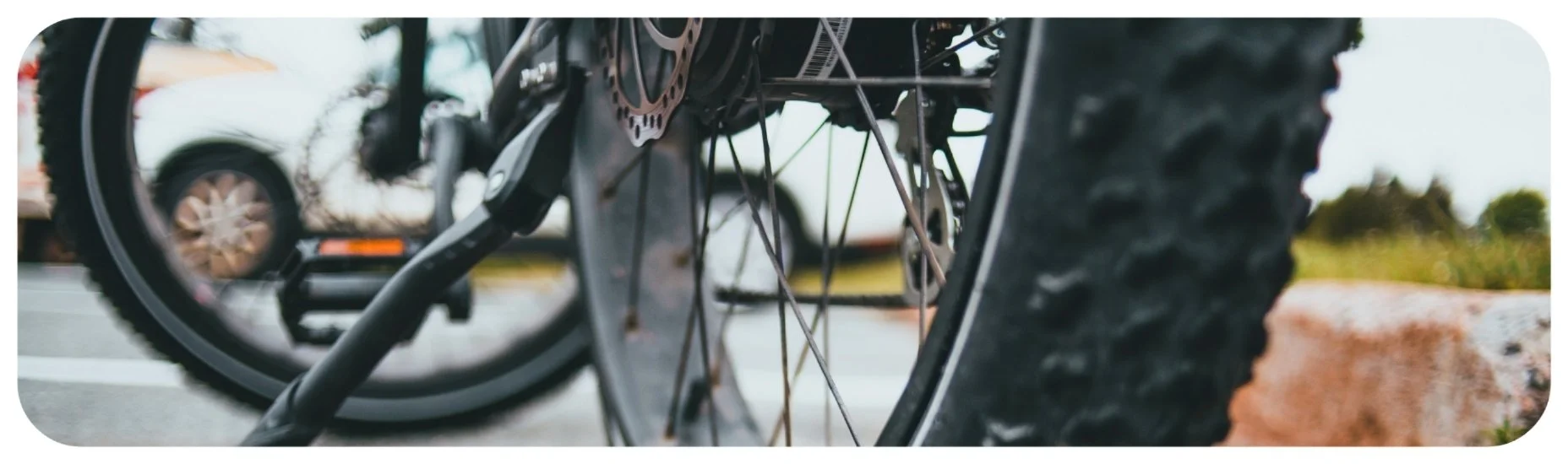 Close-up of a bicycle wheel near passing traffic, highlighting Iowa bicycle accidents involving motor vehicles.
