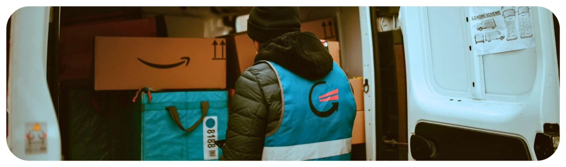 Delivery worker loading packages into a vehicle for work in Iowa.