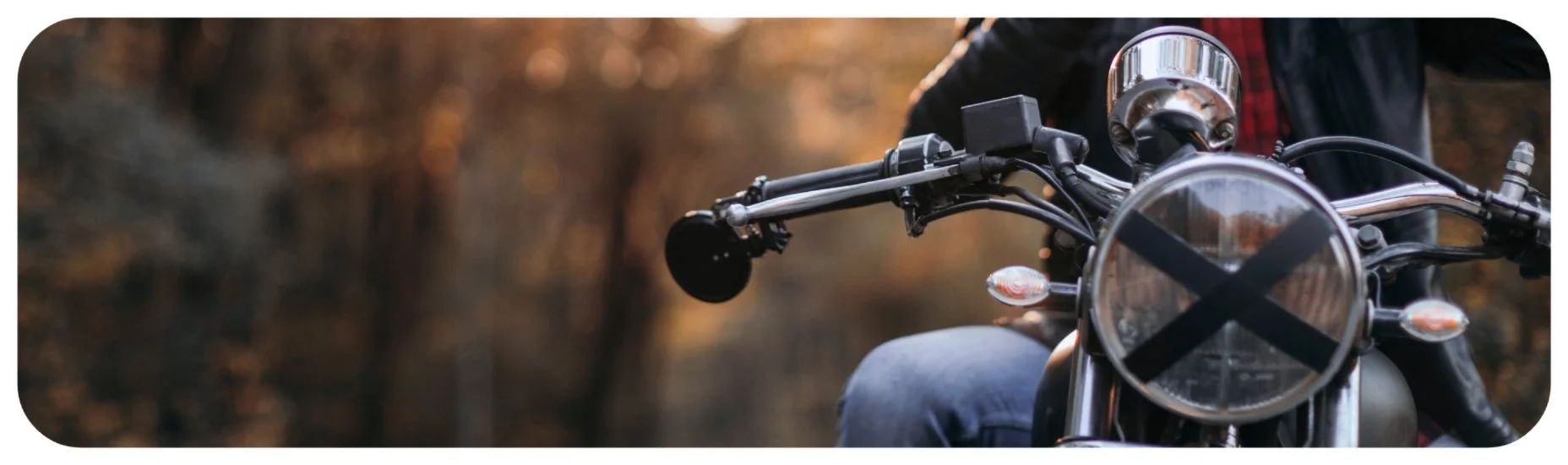 Motorcycle traveling on a wooded roadway with limited visibility, highlighting safety risks for riders in Iowa.