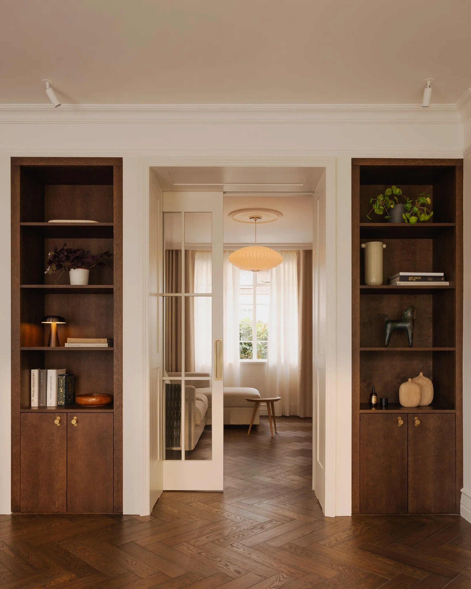 An view of the snug with internal sliding doors, dark oak timber floors and bespoke timber joinery at a renovation project in Hampstead Garden Suburb Conservation Area - Rees Architects