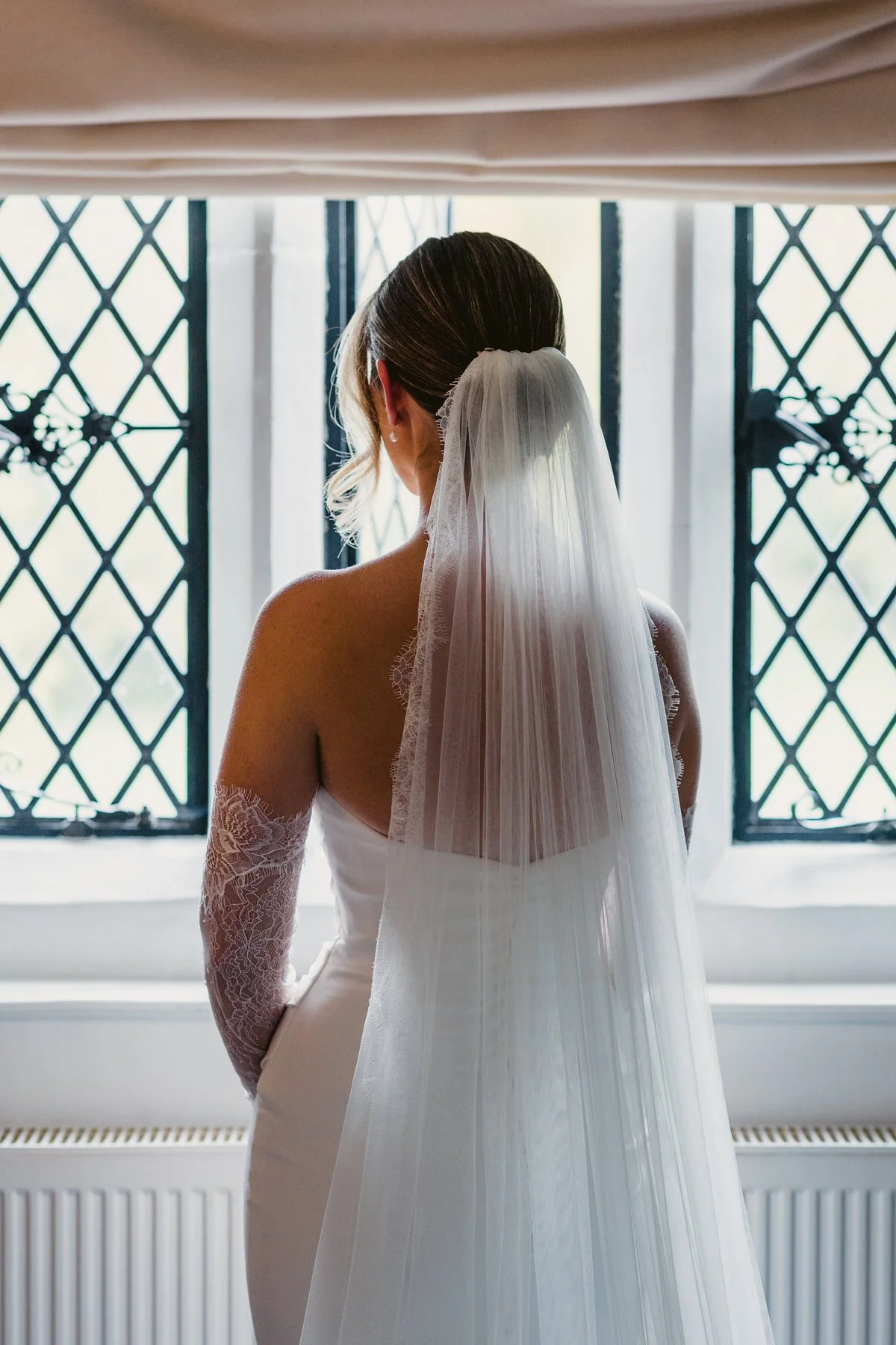 bride looking out window at great fosters