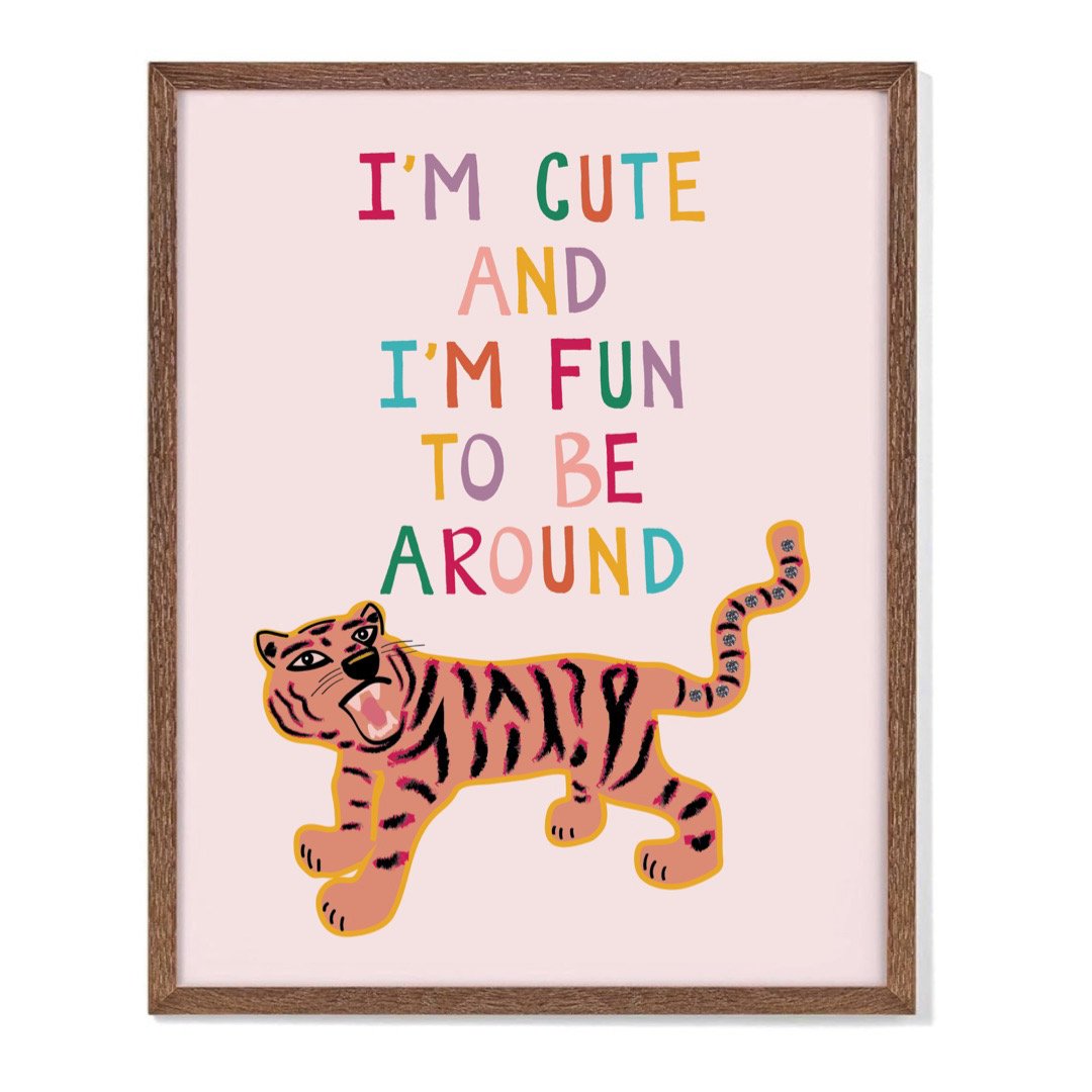 A framed art print of an original illustration by KJ of a roaring tiger with diamonds in her tail, and hand lettering that reads I'm Cute and I'm Fun to be Around.