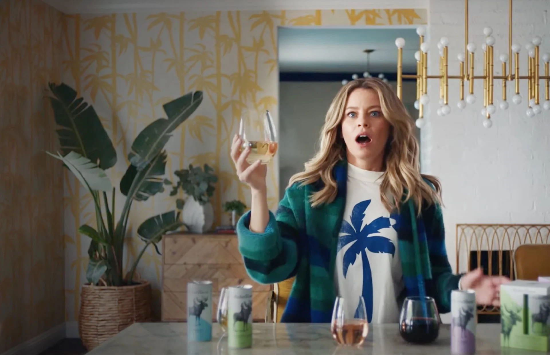 Elizabeth Banks holding a glass of wine in an Archer Roose commercial.