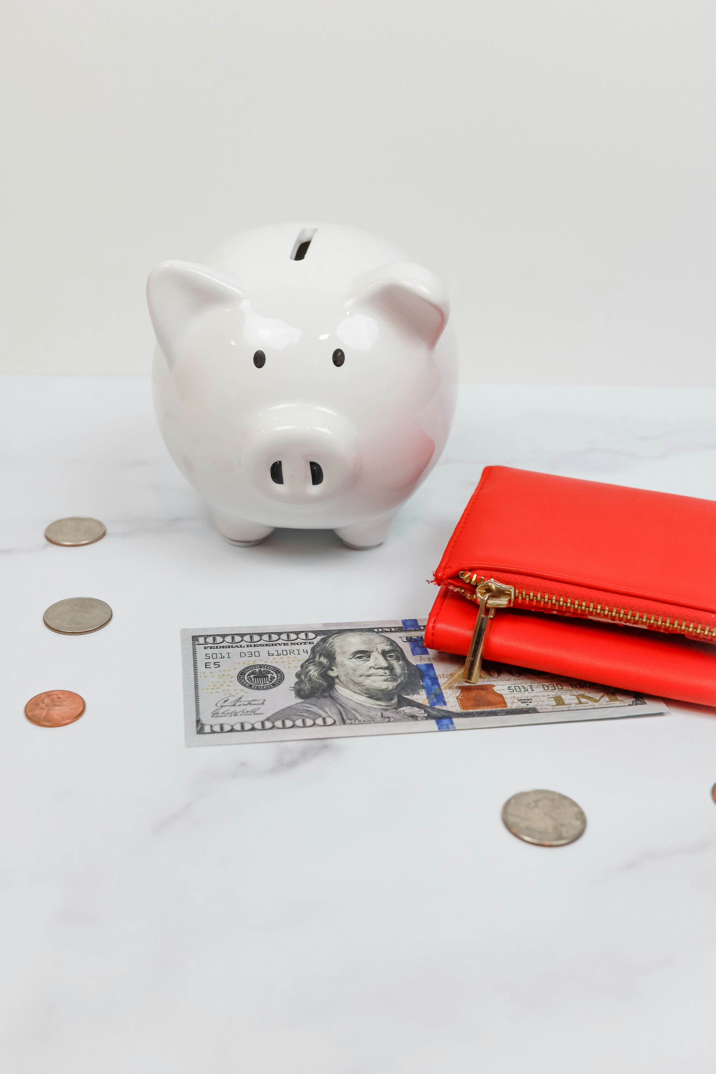 A piggy bank next to a wallet and US currency to illustrate college savings