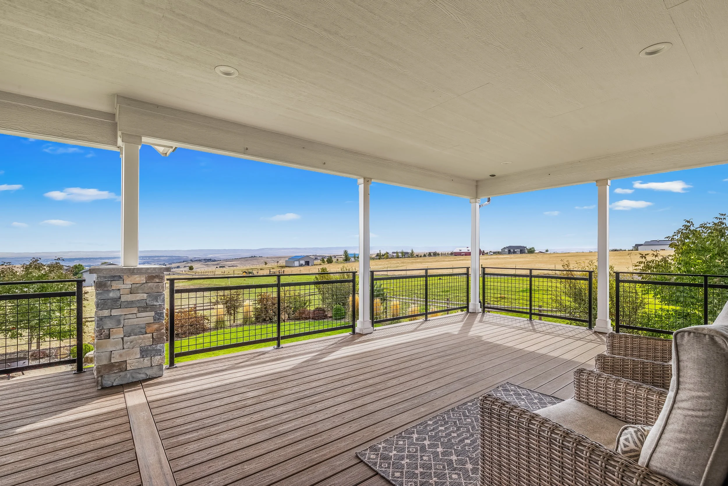Covered deck overlooking the fenced backyard and pasture