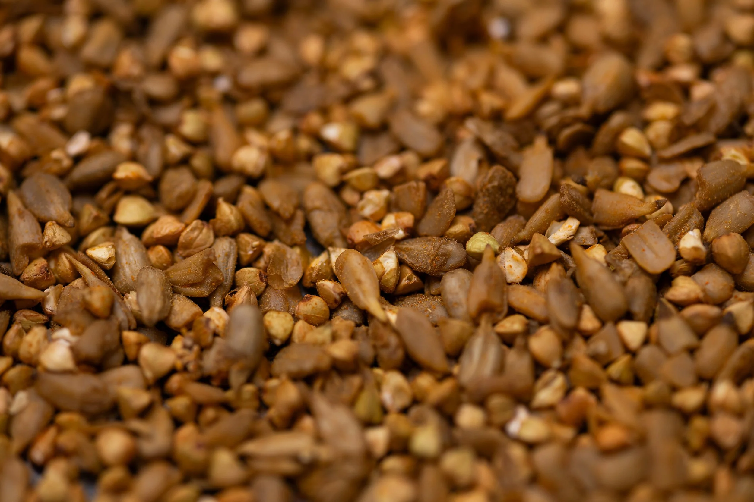 Mischung aus gekeimten getrockneten Sonnenblumenkernen, Buchweizen. Leicht rötliche Färbund durch Chili und Paprikapulver