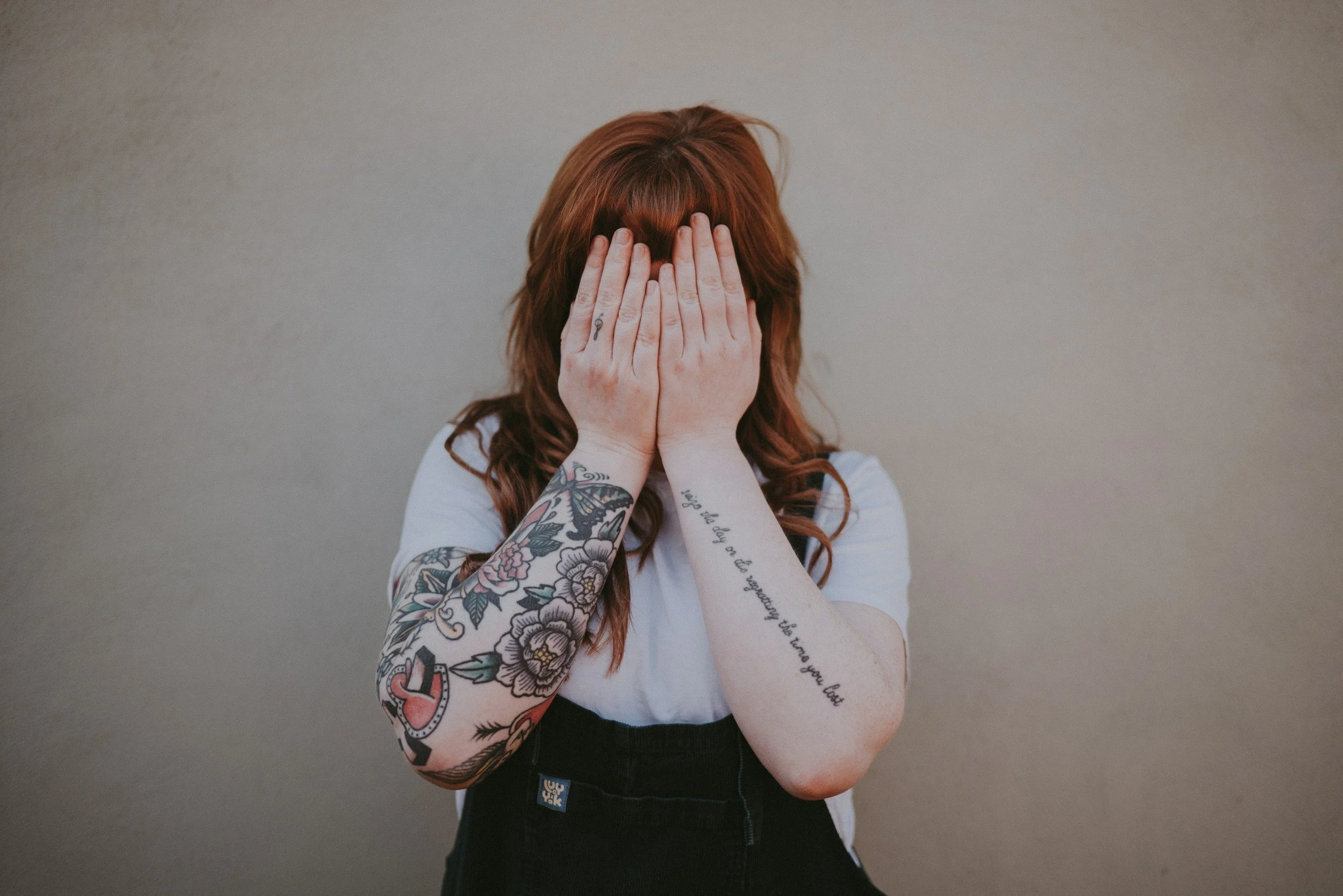 A women with red hair holding her hands in front of her face feeling guilt and shame around recent eating partners and wanting to stop the cycle.