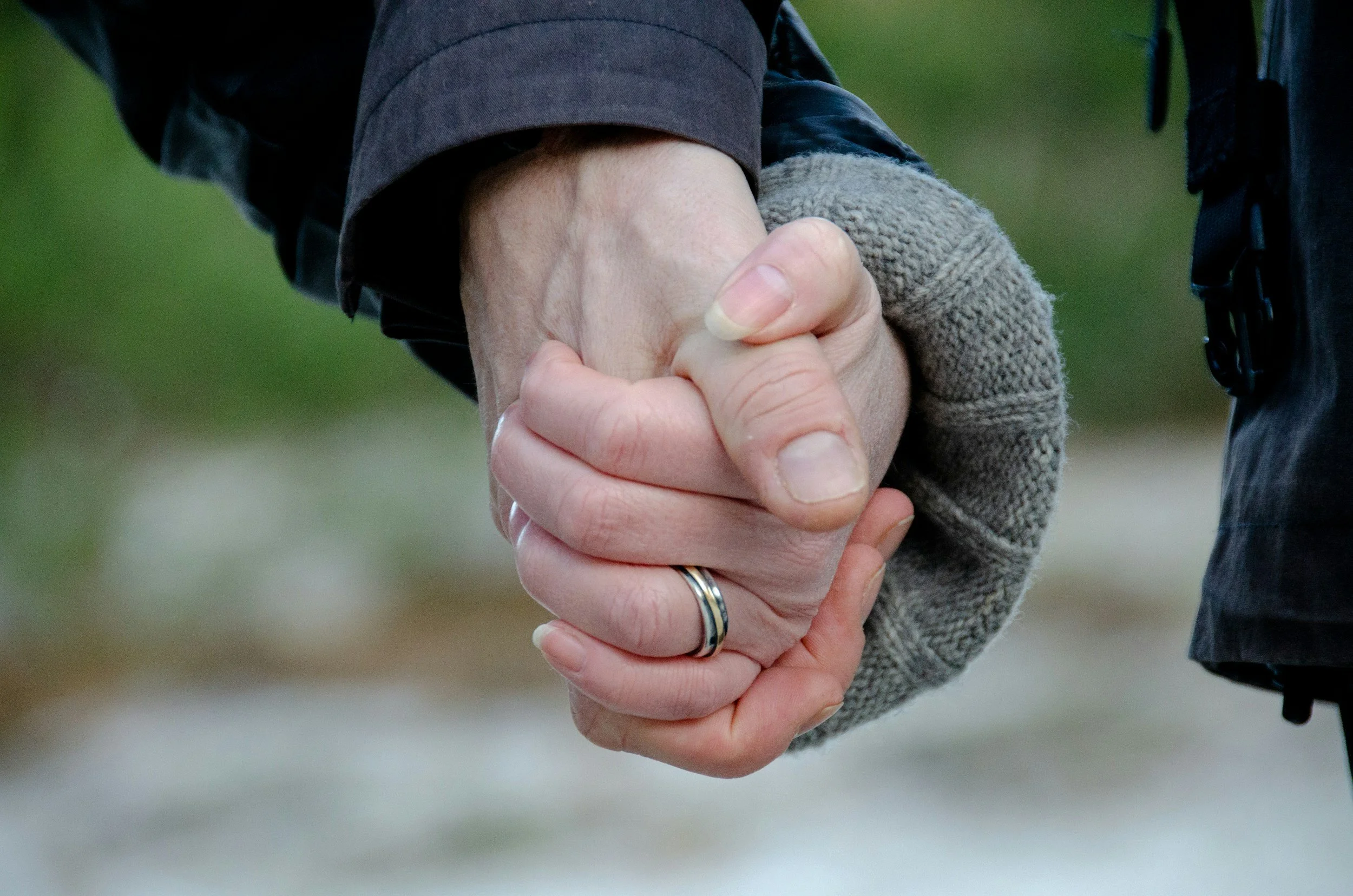 A photo of two people holding hands after a long journey in addition recovery, and being able to connect again.