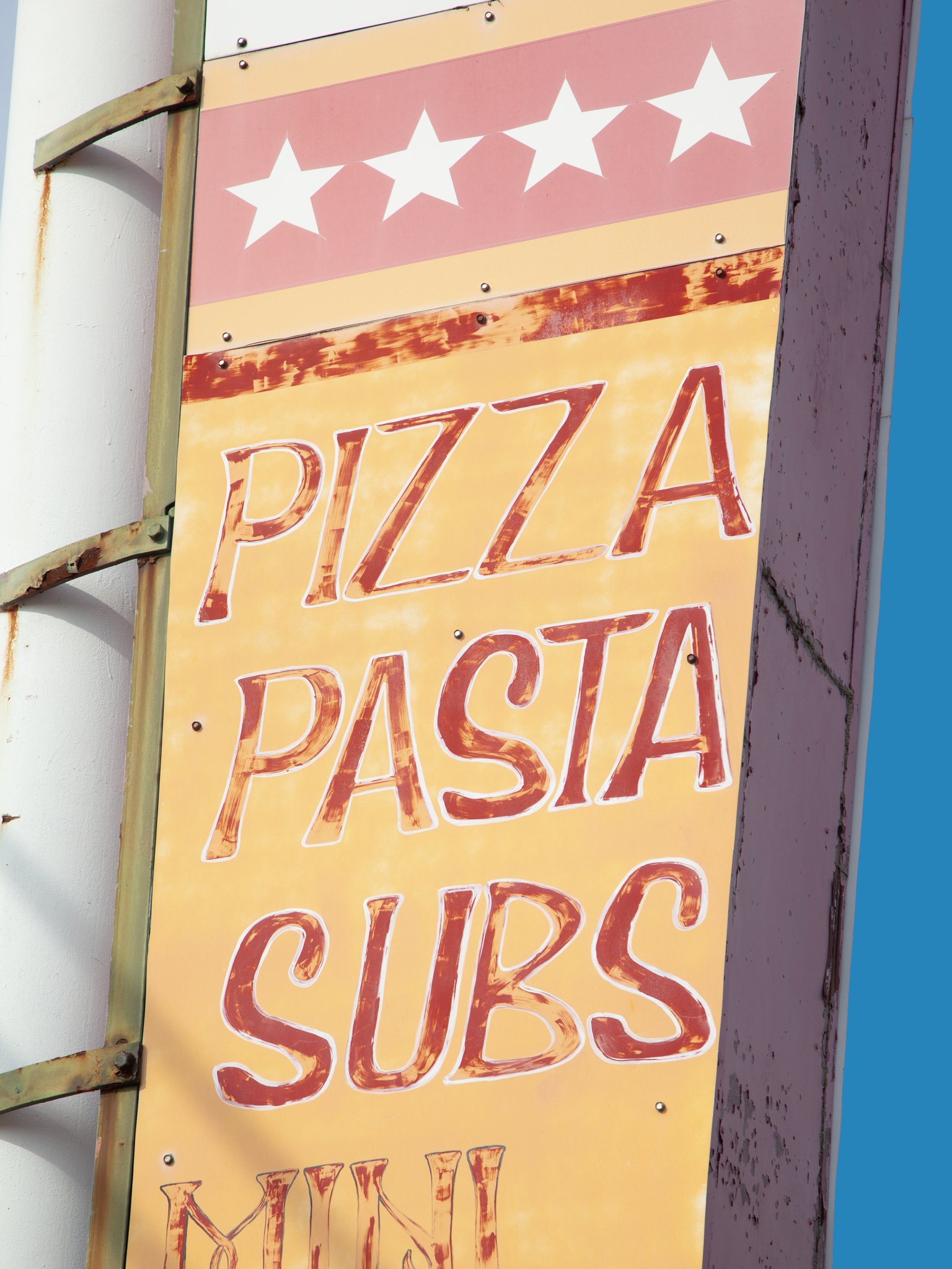 A freestanding sign with a pink and yellow background, showing a five-star rating above the word 'PIZZA' in large, distressed red letters.