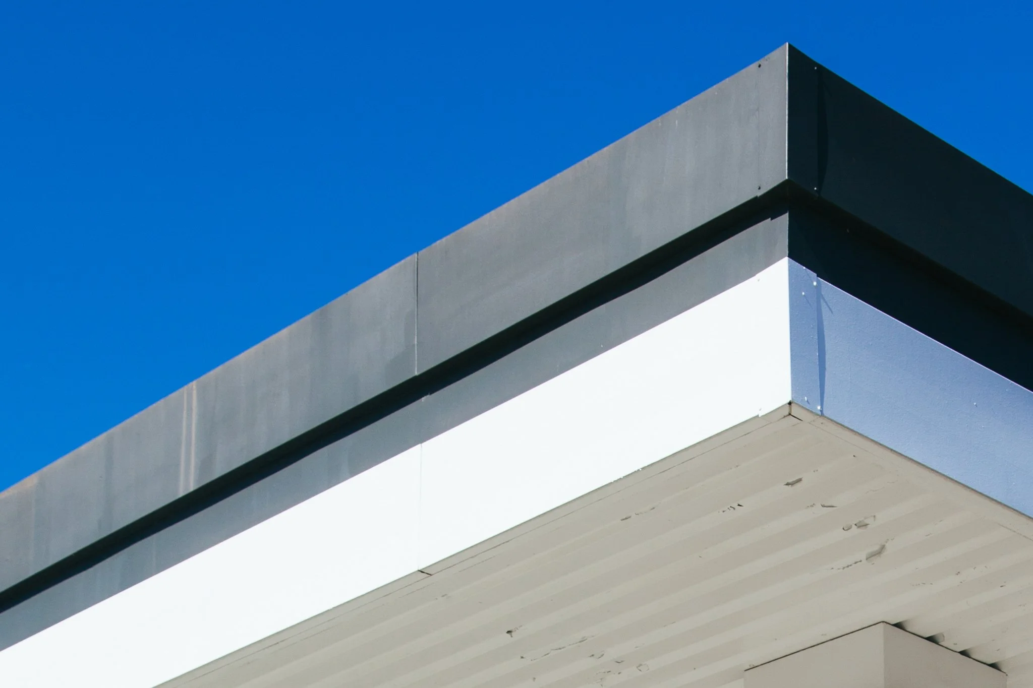 Close-up of the corner of a modern building with a blue sky background.