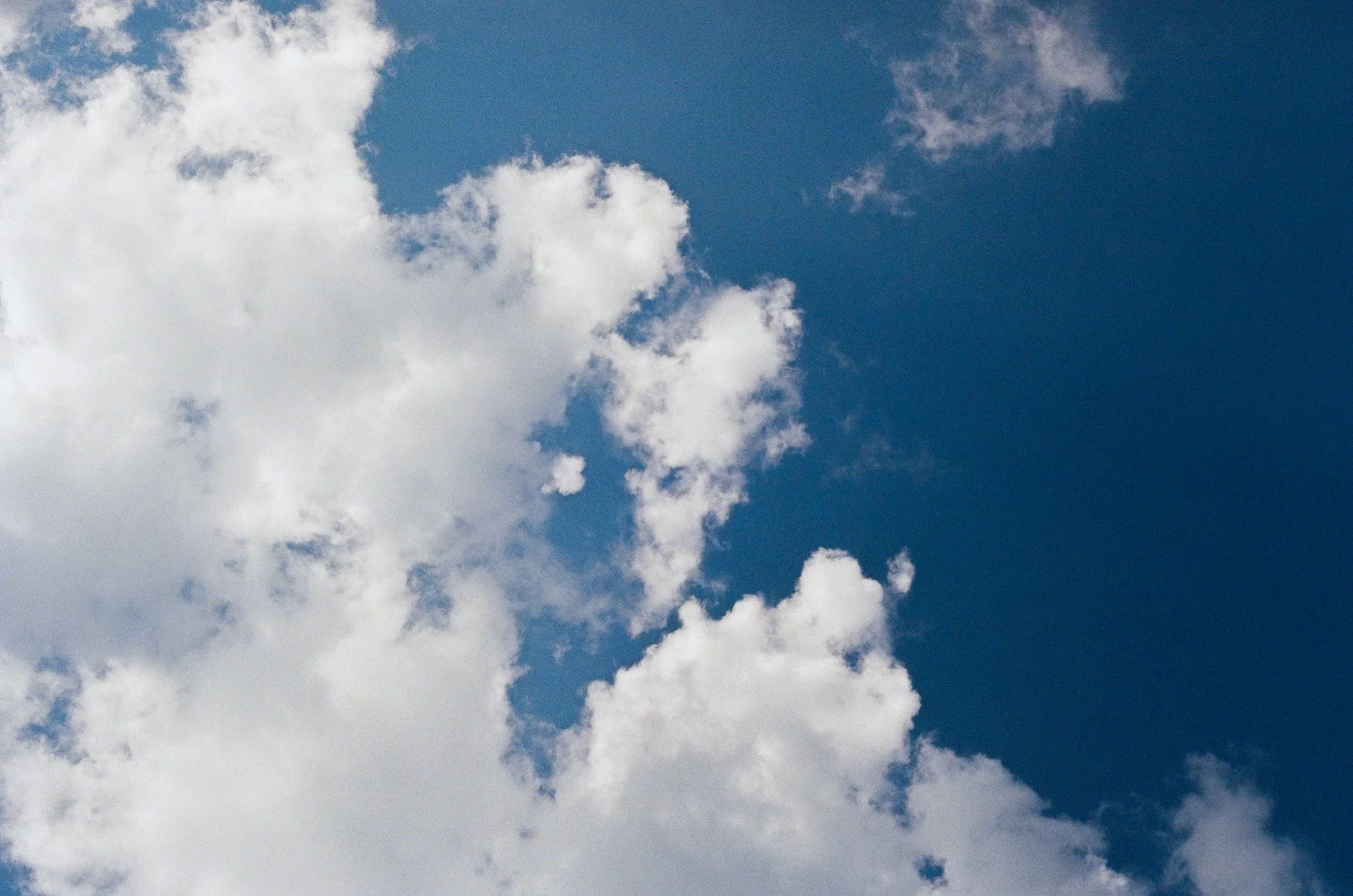 A bright blue sky with scattered white and gray clouds.