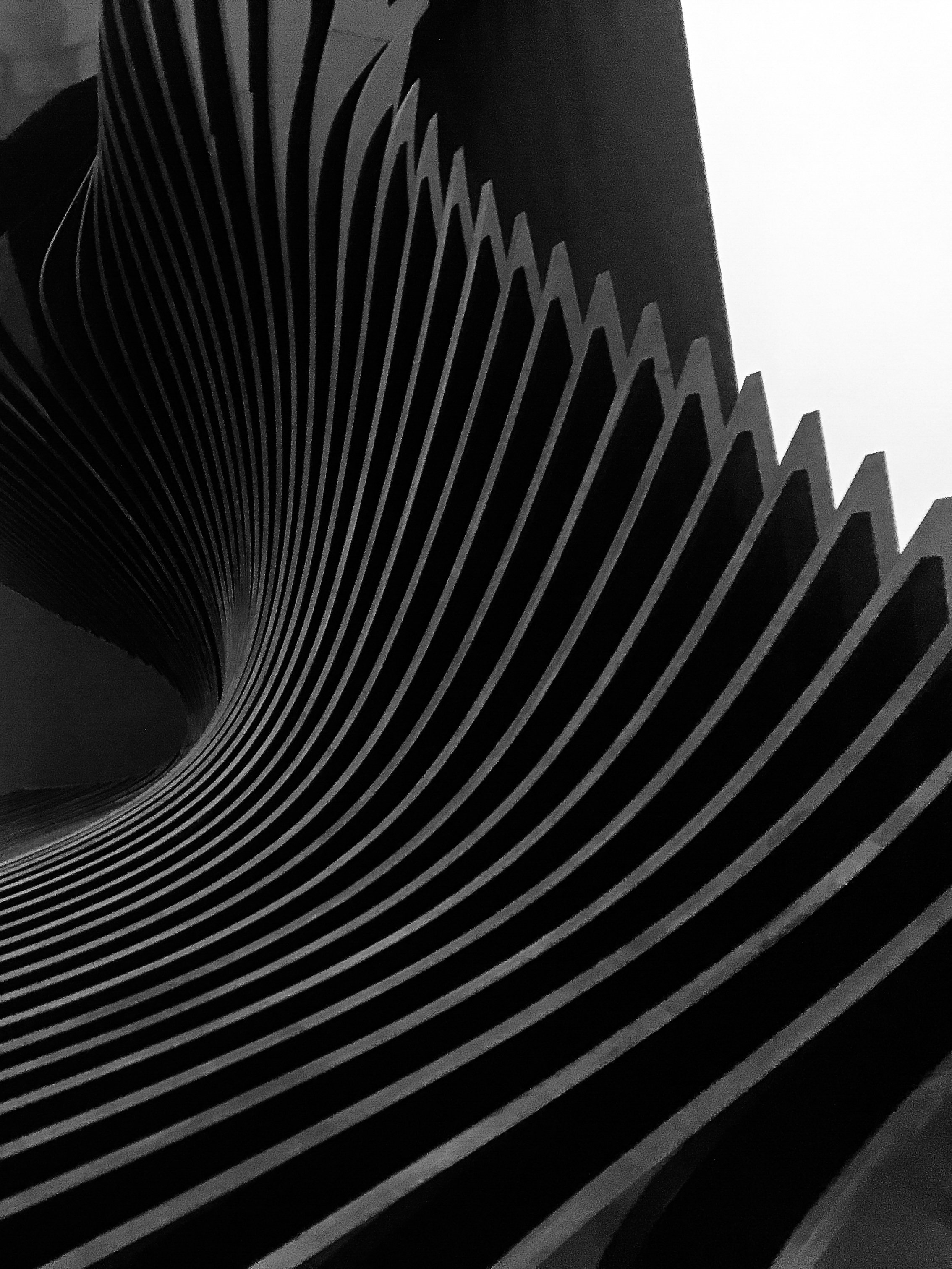 Close-up view of a modern, artistic black and white spiral staircase with contrasting lines.