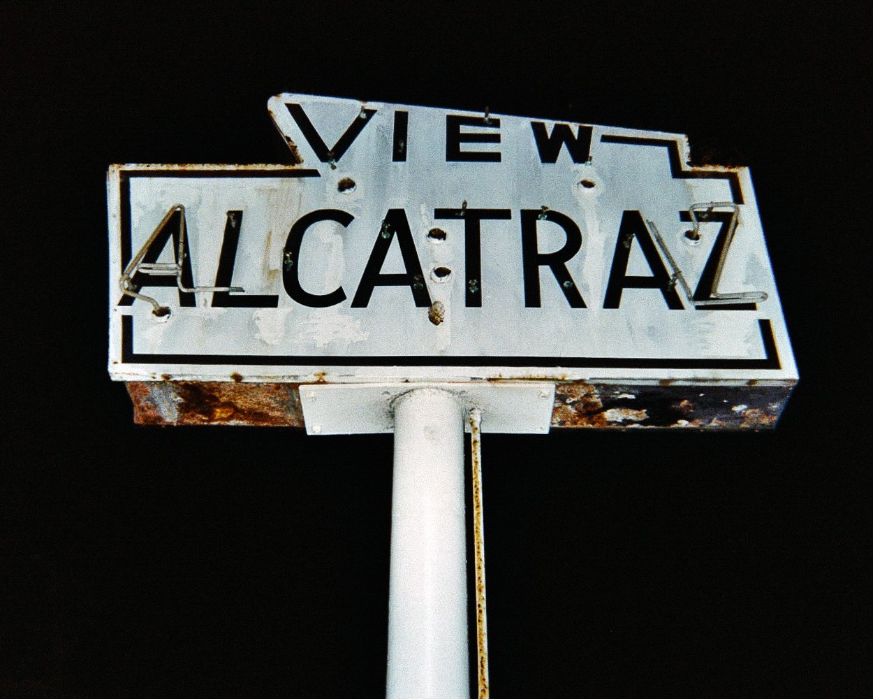 Old weathered street sign reading 'View Alcatraz' against a dark background.