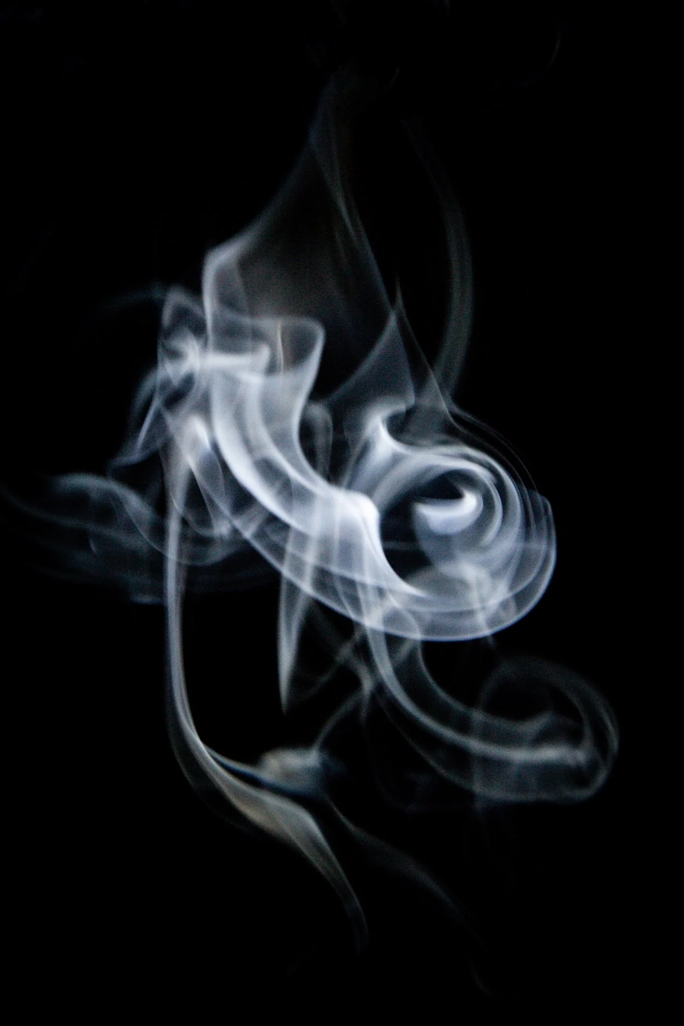 White smoke tendrils swirling against a black background.