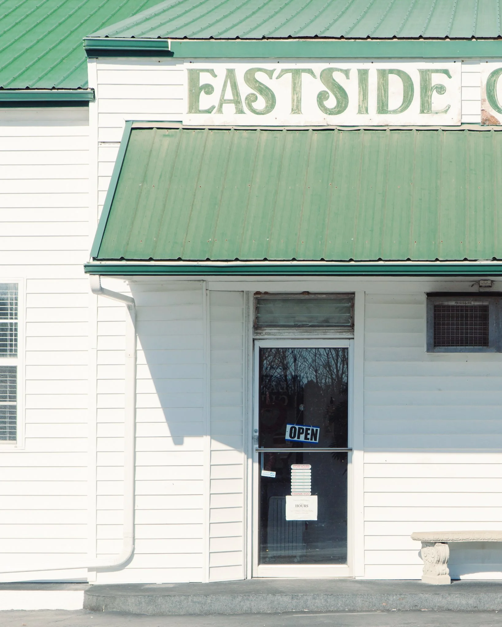White building with a green metal roof and an 