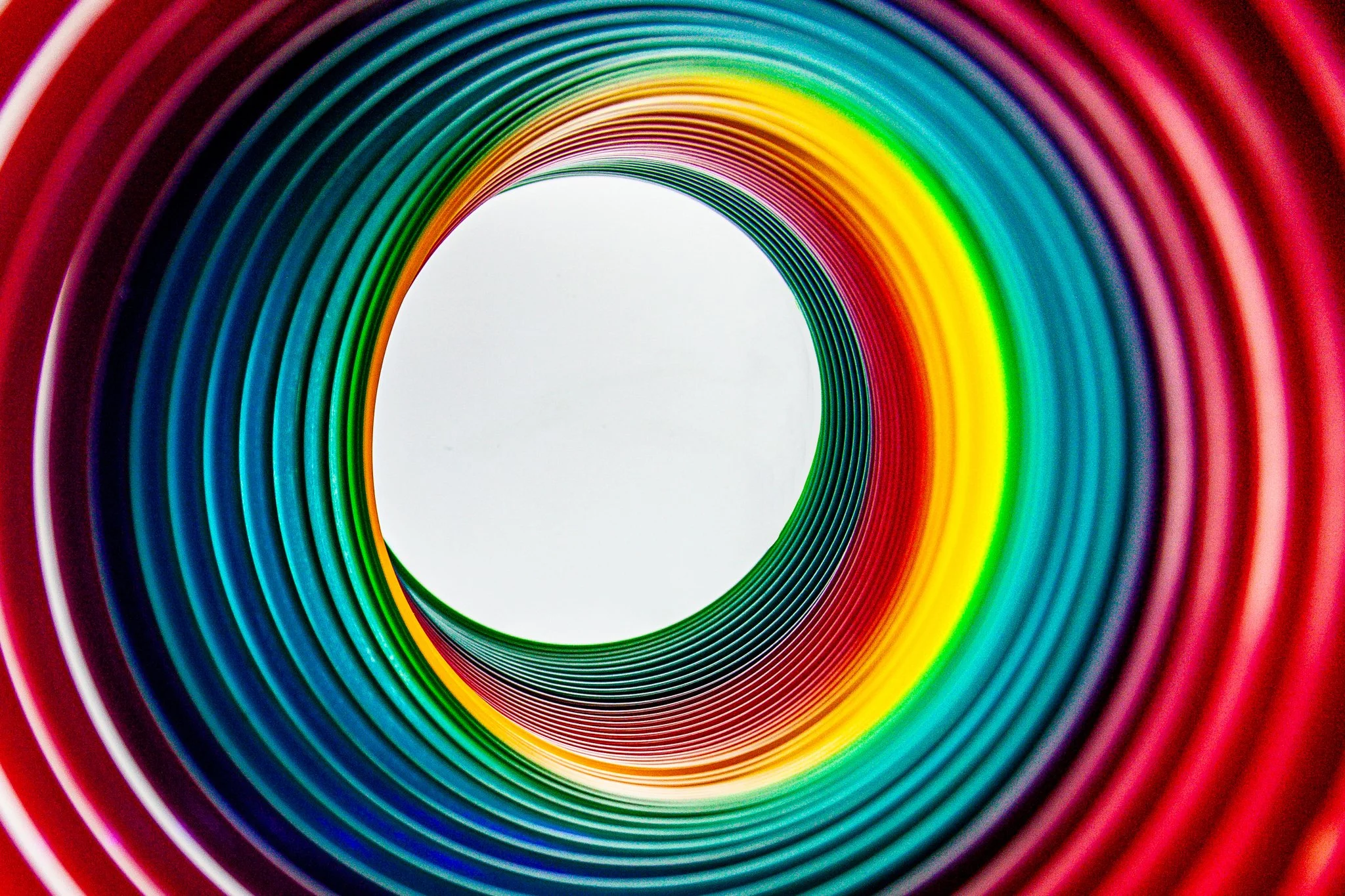 Colorful rainbow-colored coiled spiral pattern with the spiral opening at the top center.