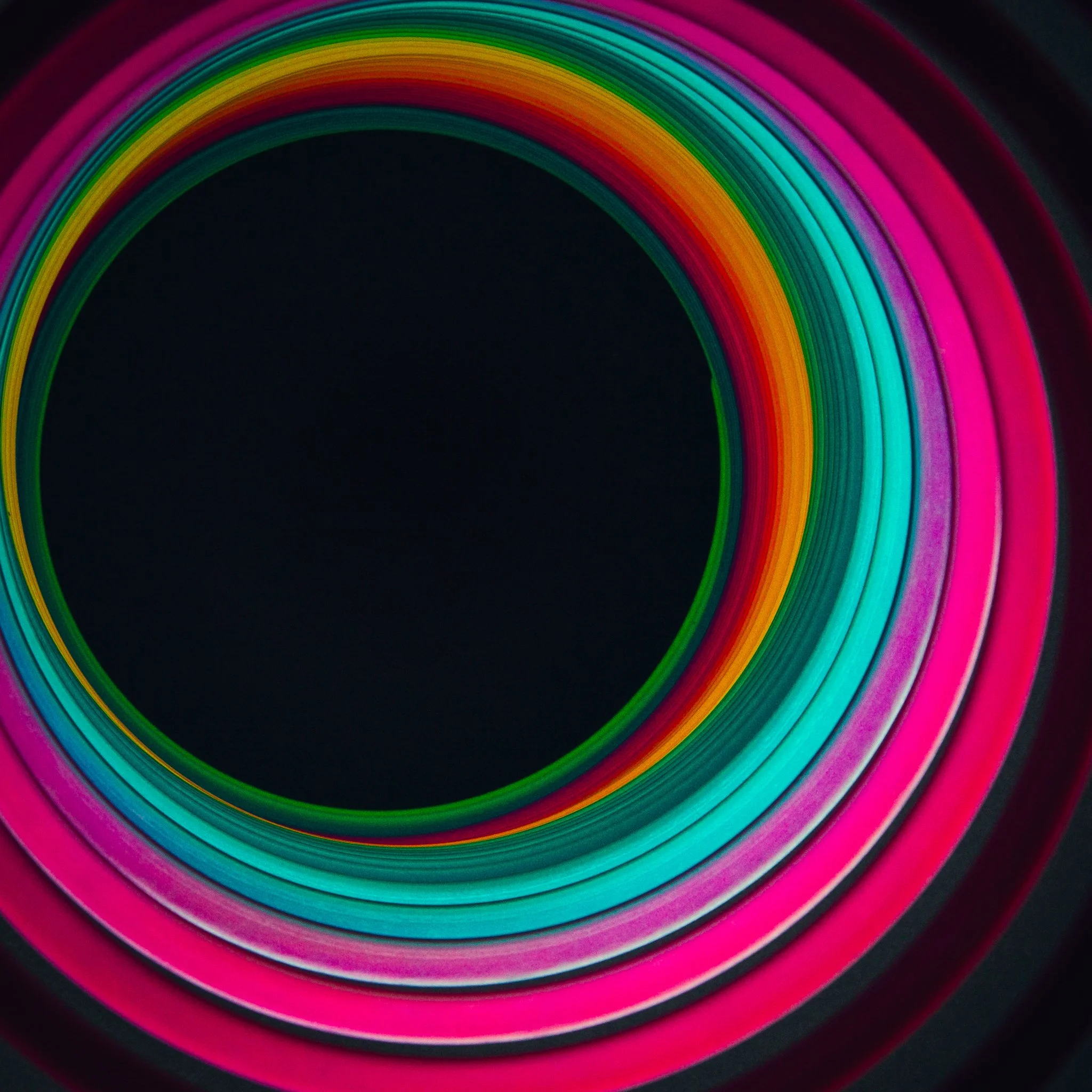 Close-up of a rainbow-colored circular pattern on a black background.