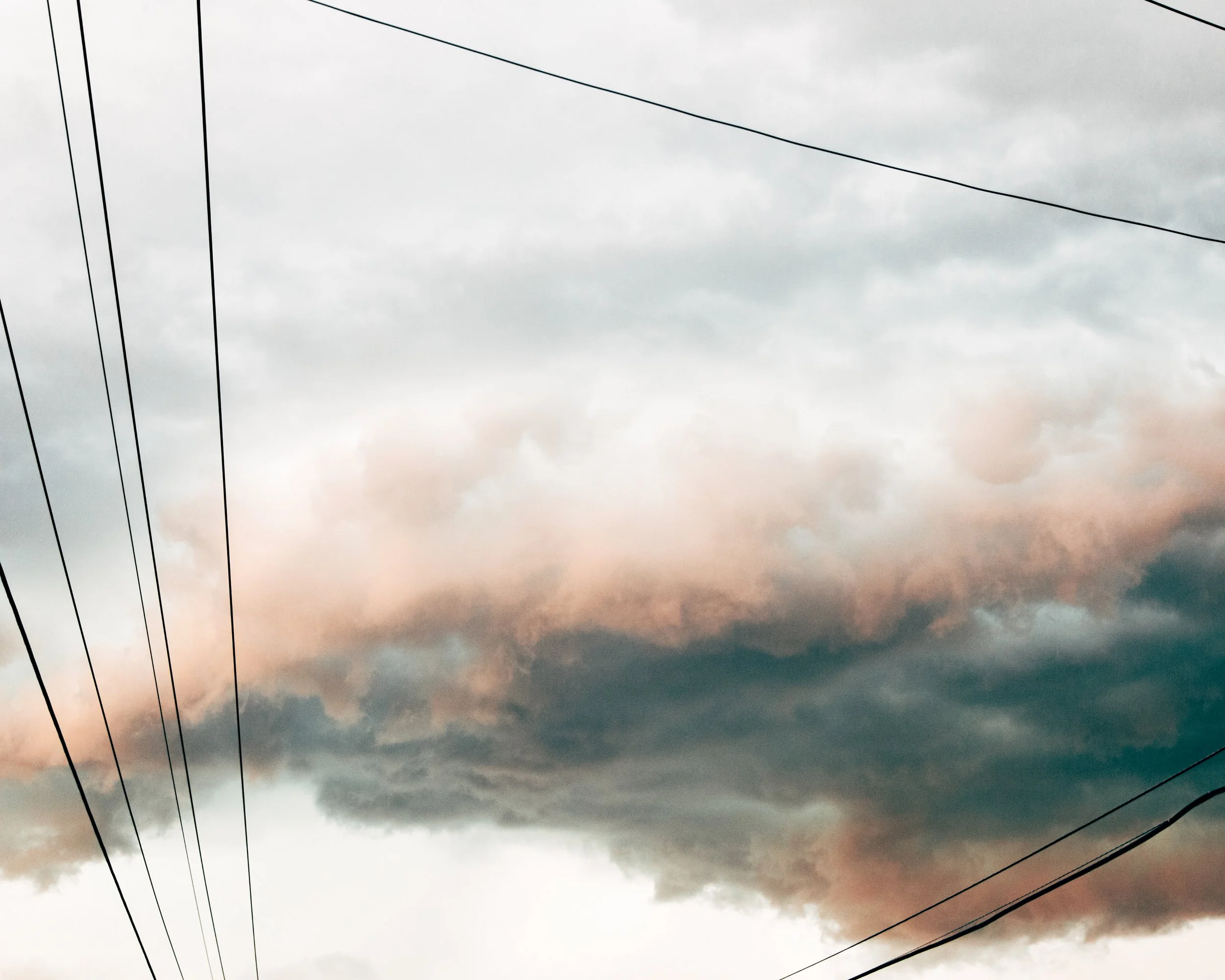 Overcast sky with dark clouds and electrical power lines.