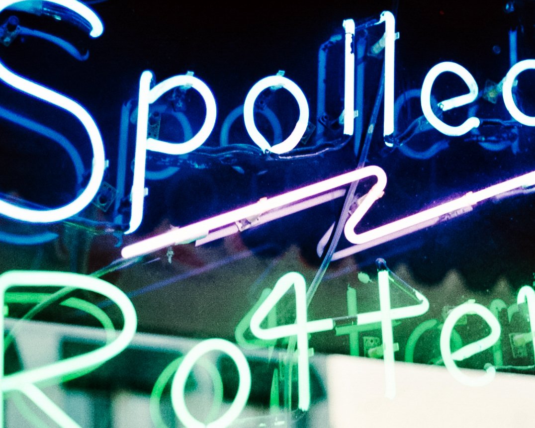 Neon sign with the words 'Spotted Rover' in blue, pink, and green lights.