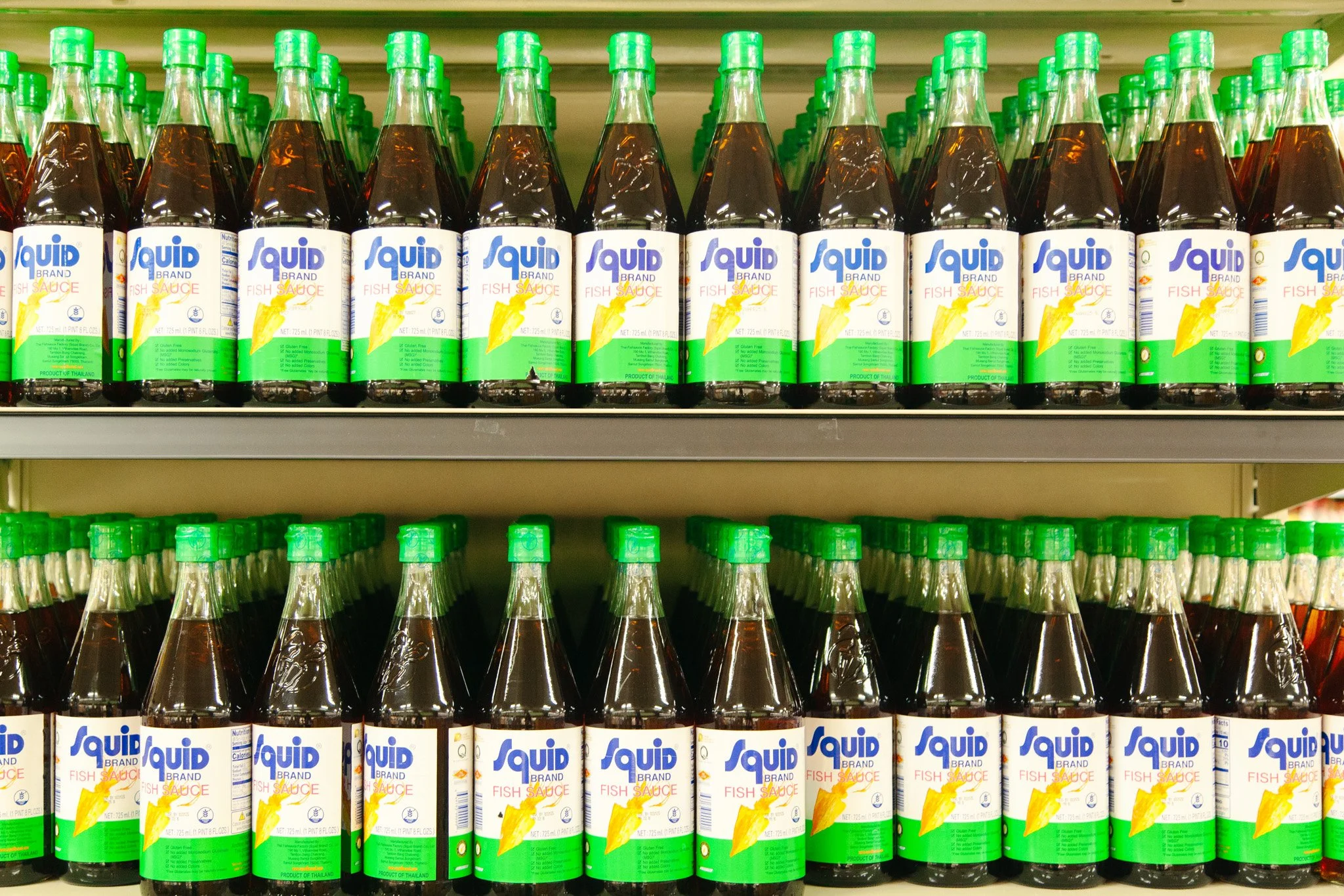 Rows of brown fish sauce bottles with green caps on store shelves at Pan-Asia Supermarket in Antioch, TN