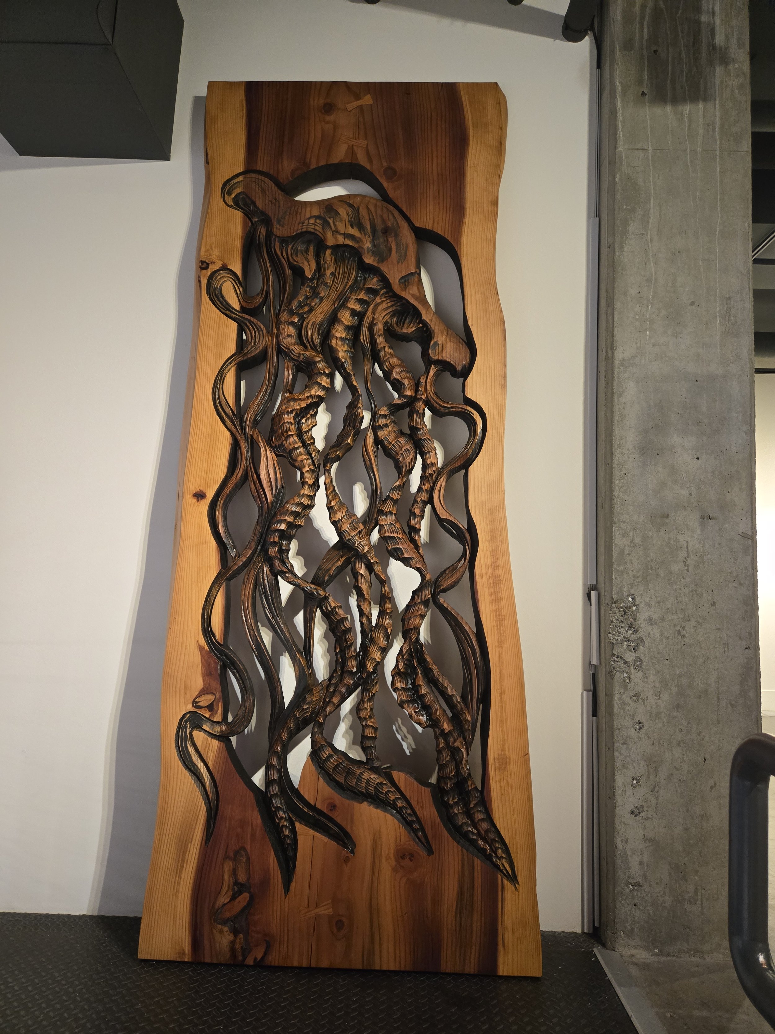 Large jellyfish in relief, wood carving hanging vertically on a wall