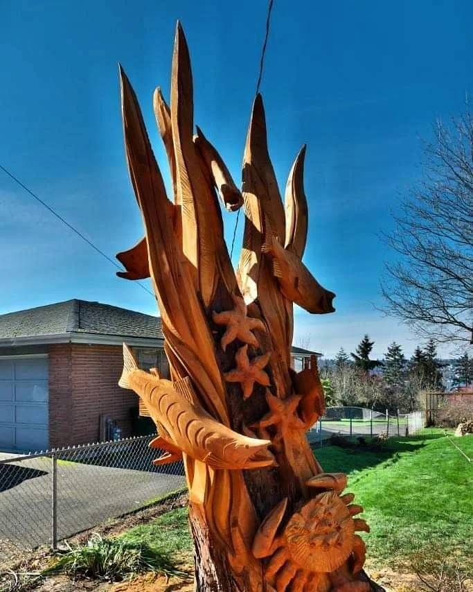 Tree stump sculpture with salmon, starfish and crab, by Tomas Vrba of Bellingham, WA displayed at private residence in Seattle, created with chainsaw