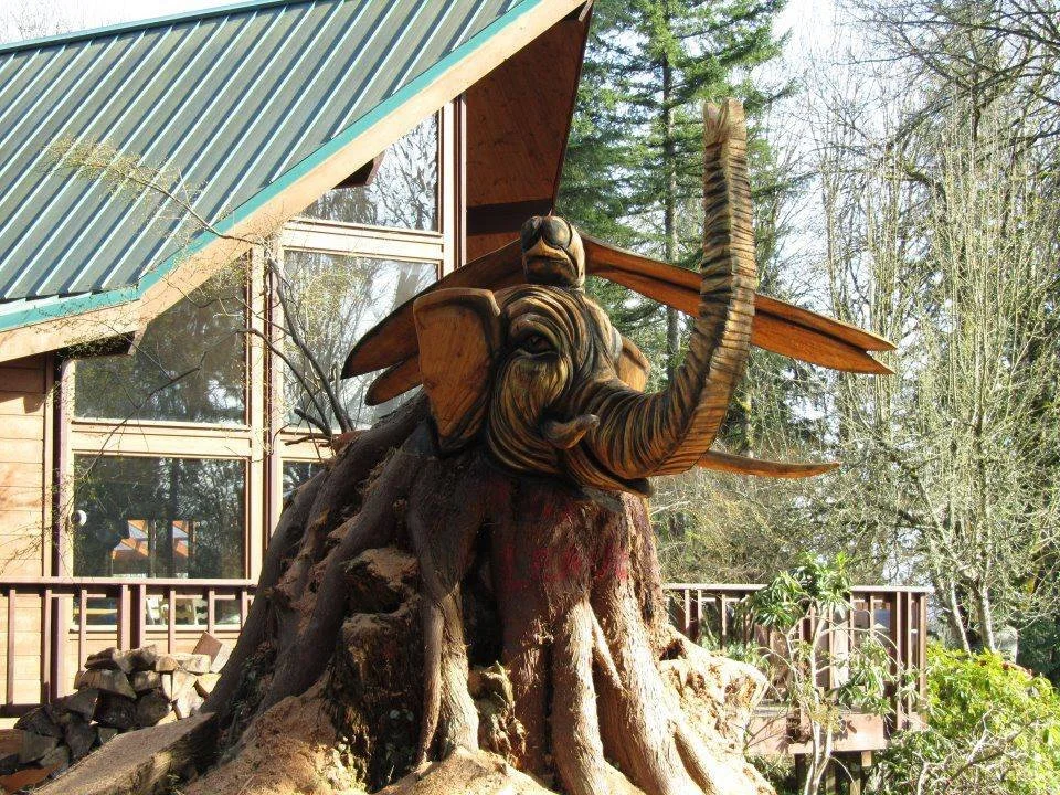 Wooden tree stump sculpture of an elephant with a bird on its trunk, at a private home in the Seattle area, created by Tomas Vrba of Bellingham, Washington.