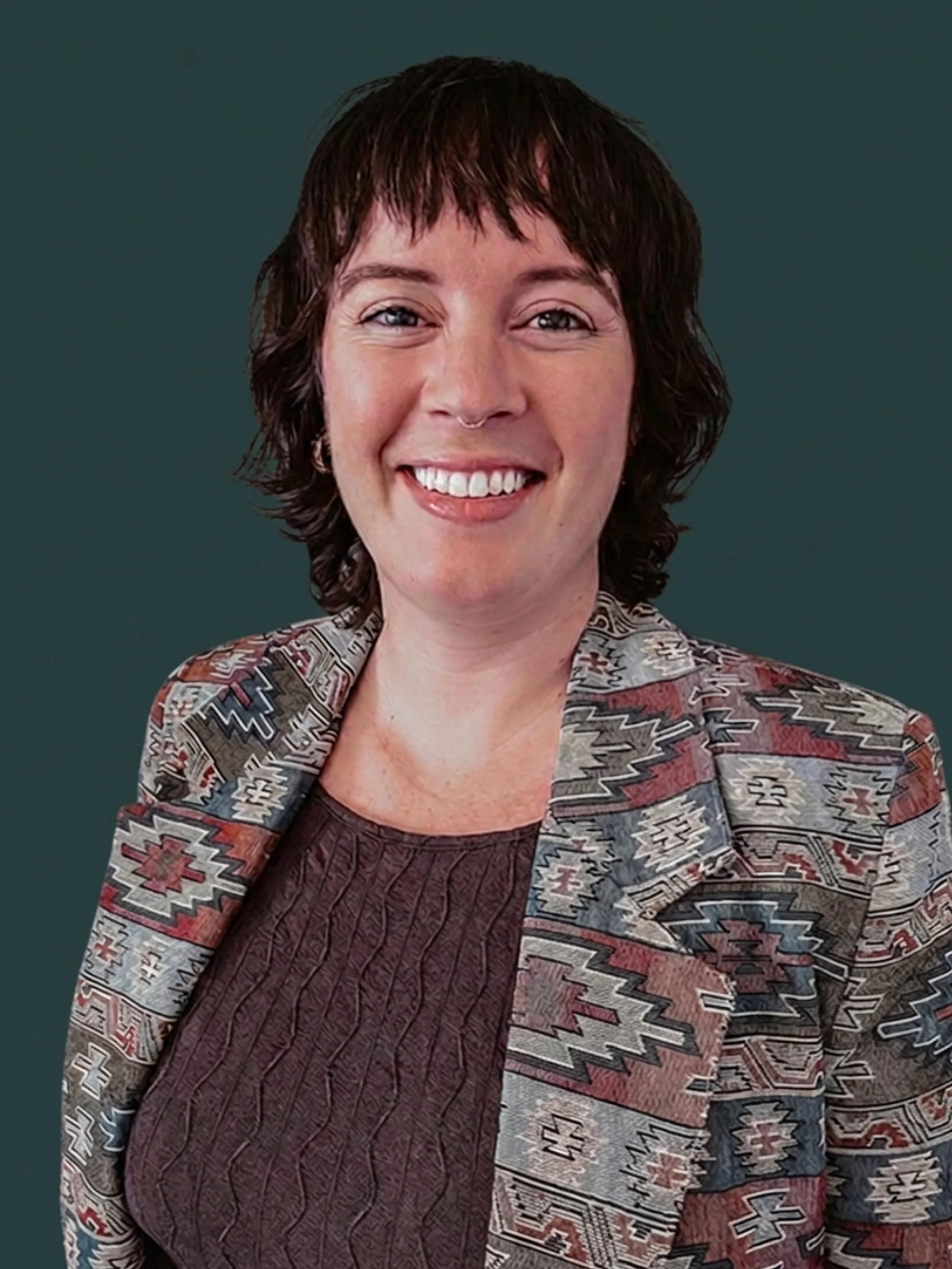 woman with short hair in front of blue/green background