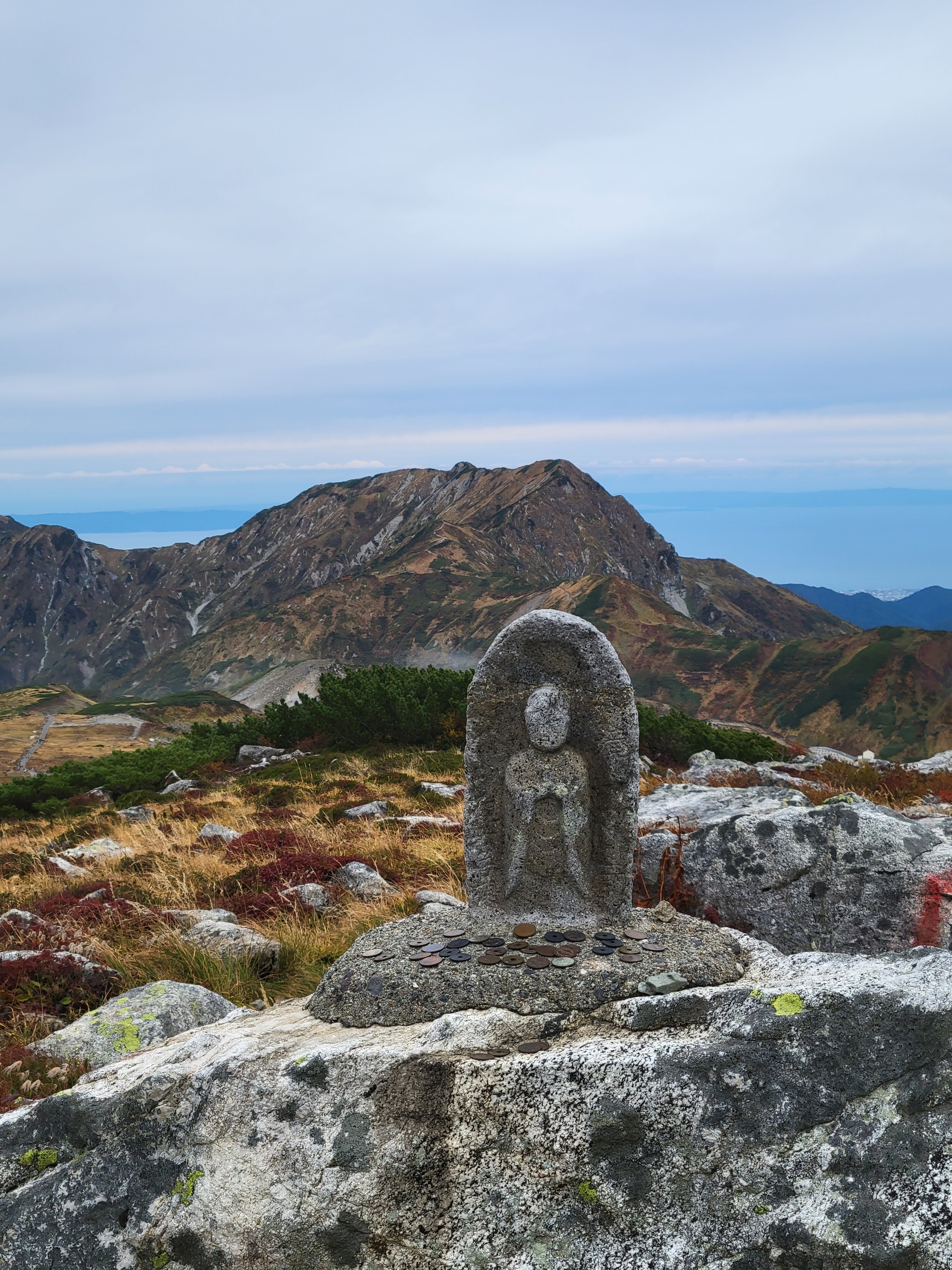 A statue where people put coins to wish for a safe hike