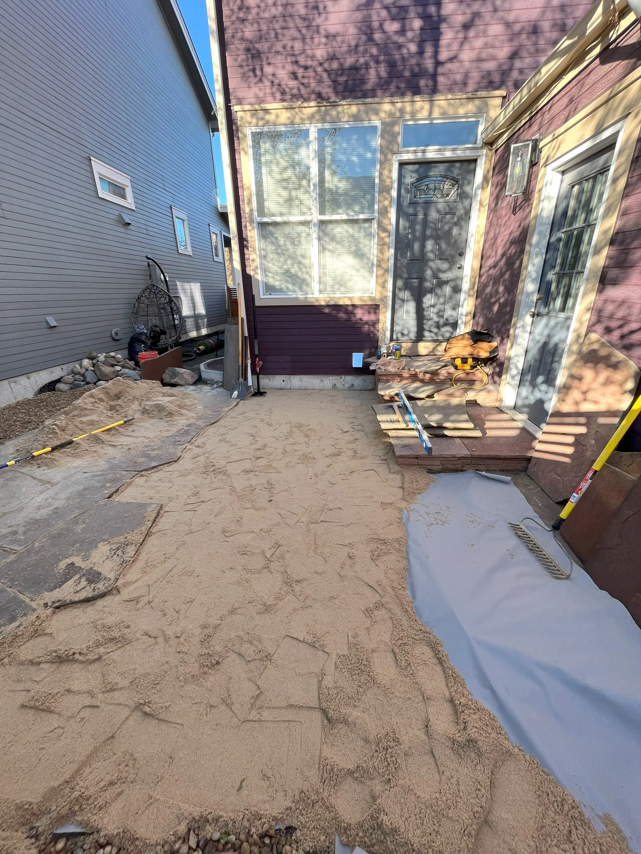 Flagstone Makeover: Weed Barrier and River Stone

We took on the task of revamping the space by adding a weed barrier, installing artificial turf along the side of the house, and replacing the existing rock with 2 tons of fresh, high-quality 3/4" riv