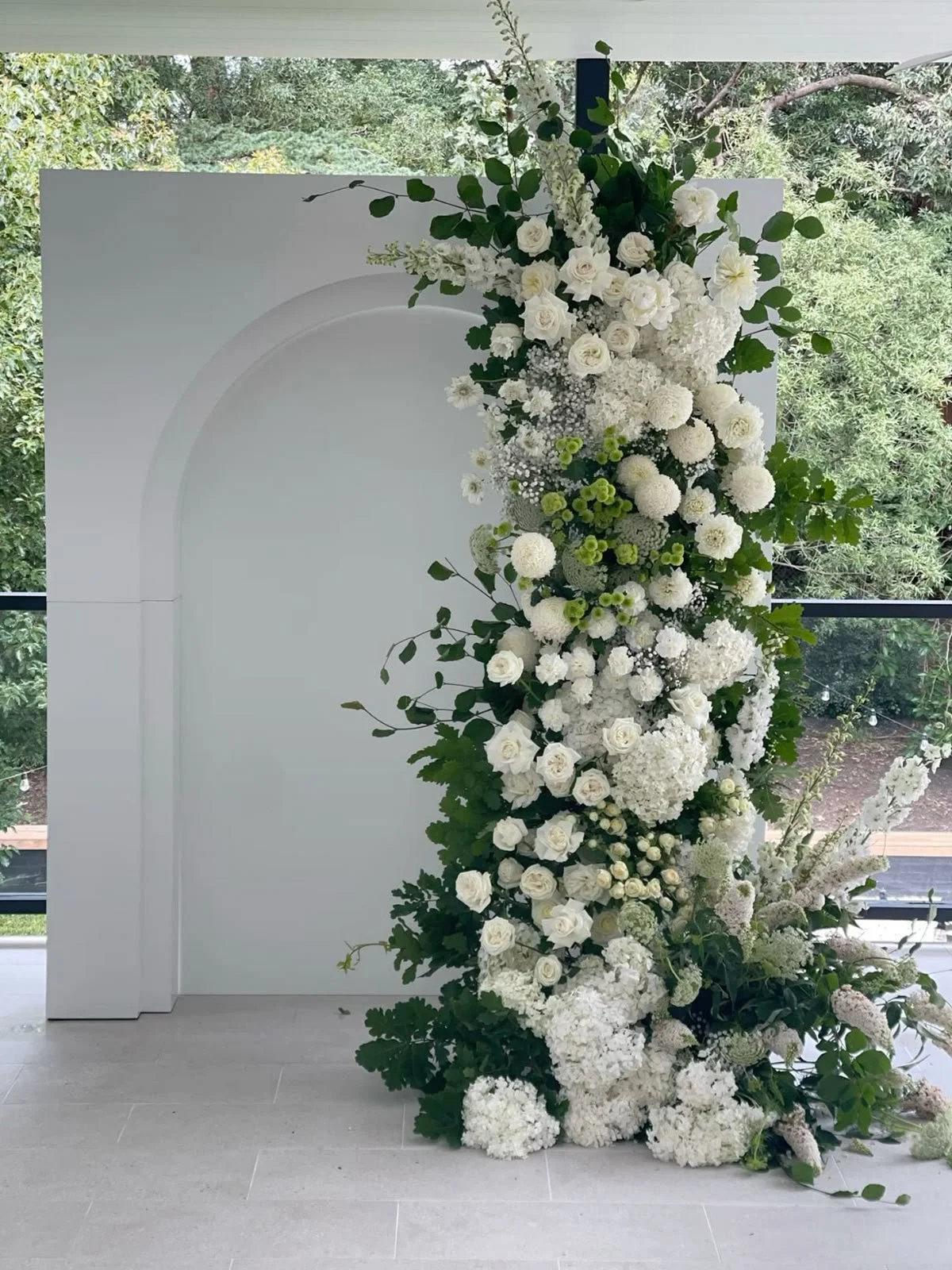 tunning event backdrop featuring floral arrangements and elegant draping."