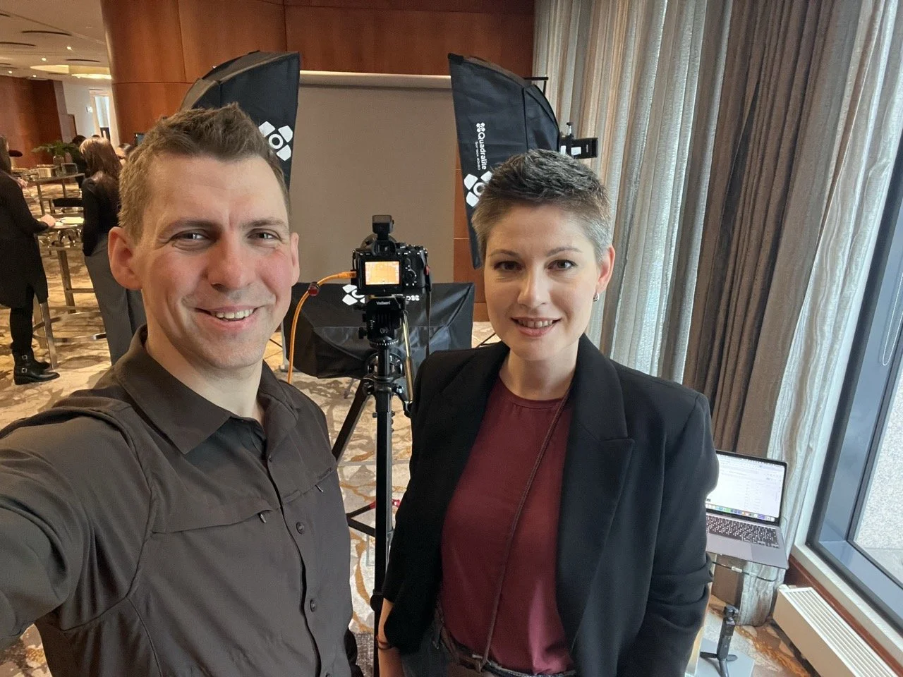 Behind the scenes of a conference photoshoot with photographer and subject near lighting equipment