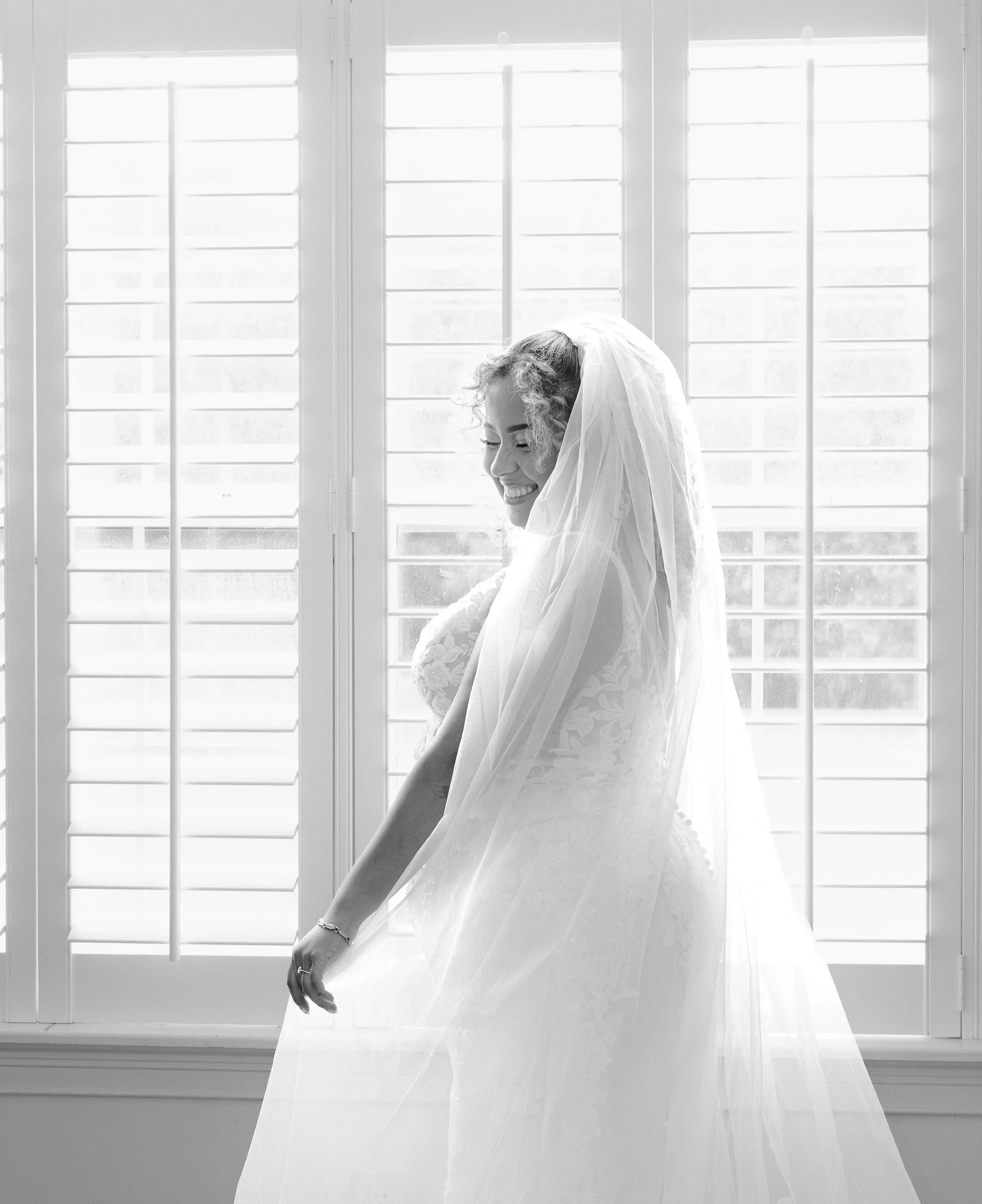 An emotional getting ready moment featuring a bride backlit by a window,  in an Airbnb venue in Kingsland South Georgia, photographed by LUX Photo + Film